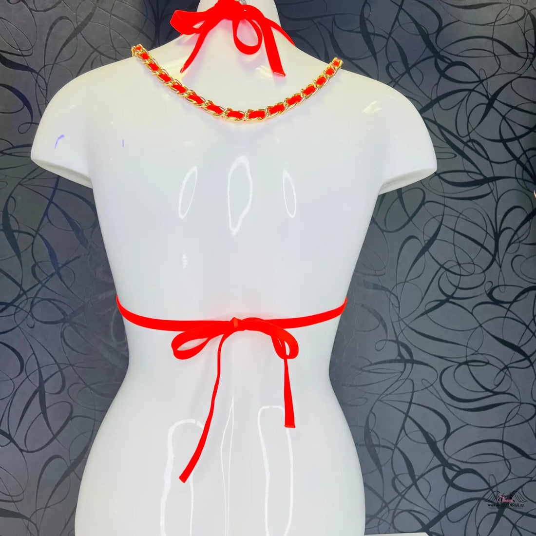 Bílý manekýn s červenými ozdobami kolem krku a pasu, horní díl plavek Harper