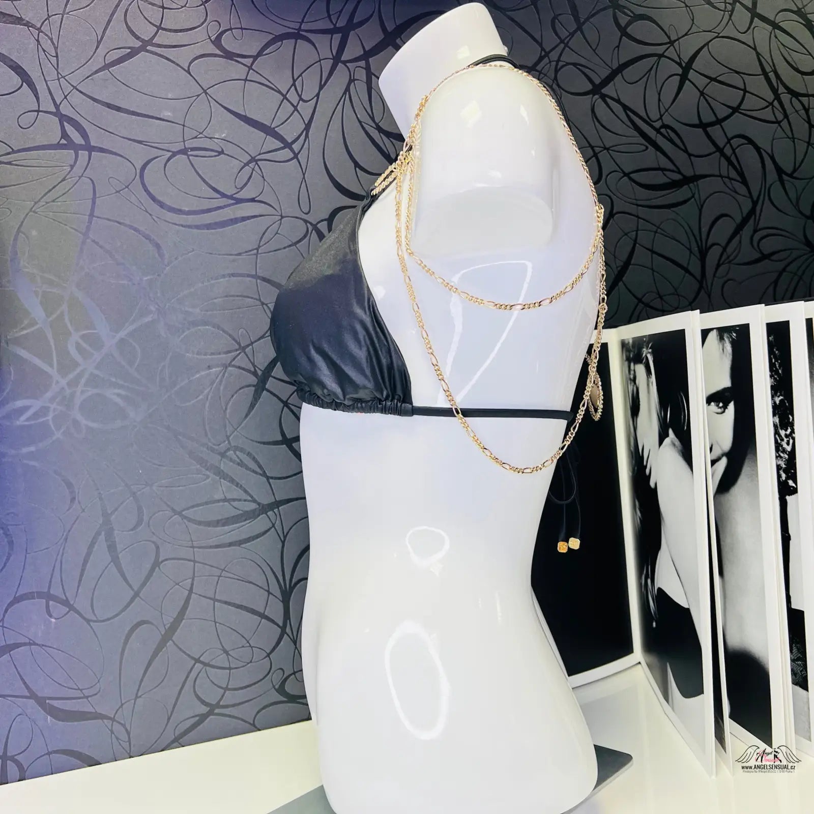Bílý mannequin s černým horním dílem plavek Kiona a zlatými ozdobami