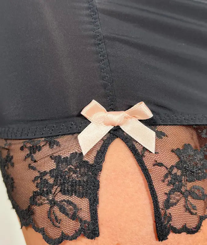Žena ve černé krajkové slip s růžovou mašlí z produktové řady Agent Provocateur Joseline Slip Black