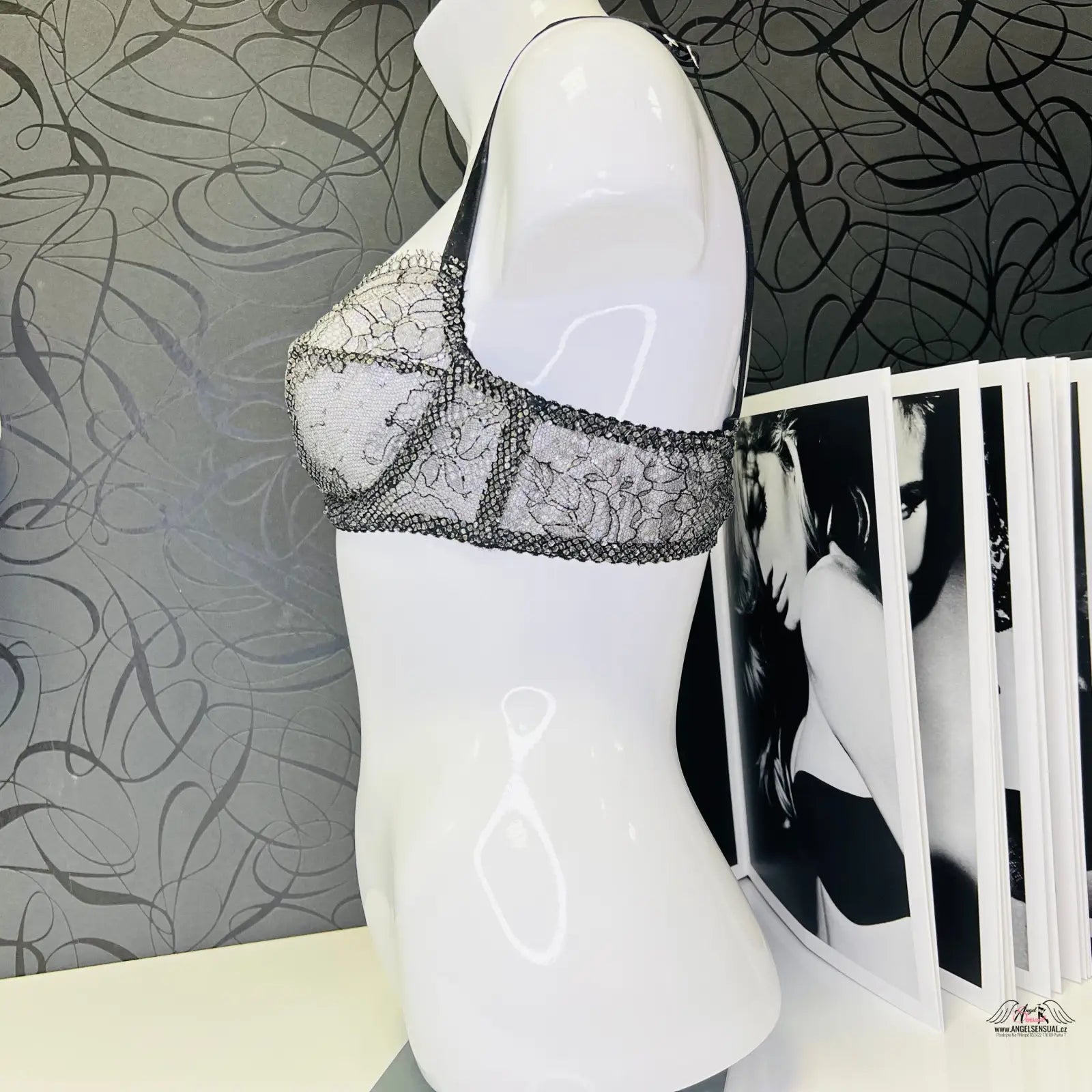 Manekýn s černou stahovací podprsenkou Sianna Black Silver a časopisem na stole