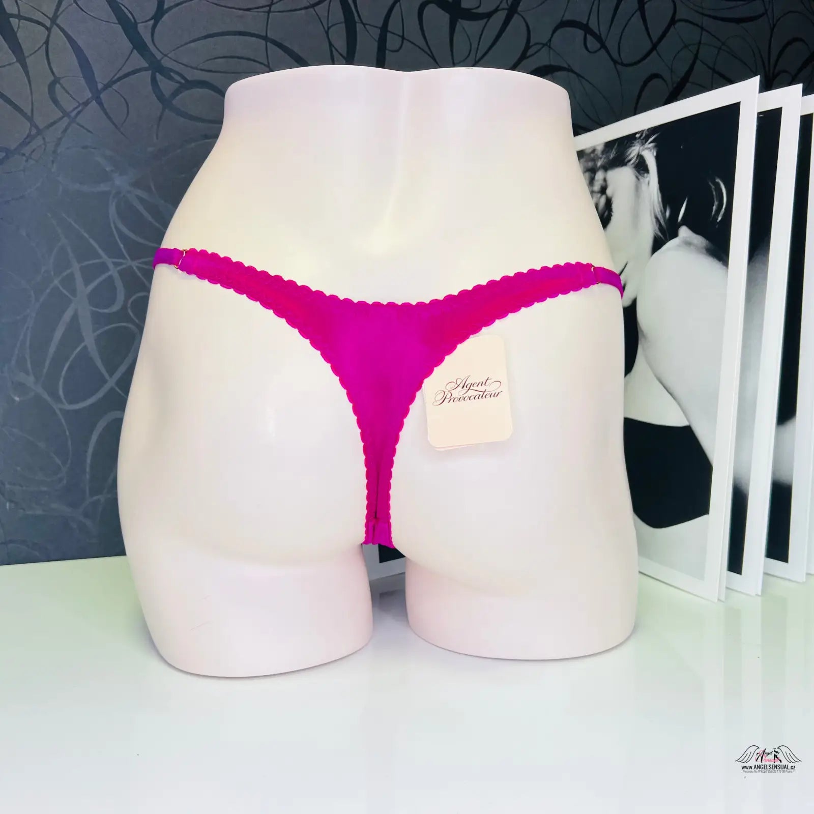 Hot pink tanga Molly s jemnou krajkou od Agent Provocateur na bílé figuríně