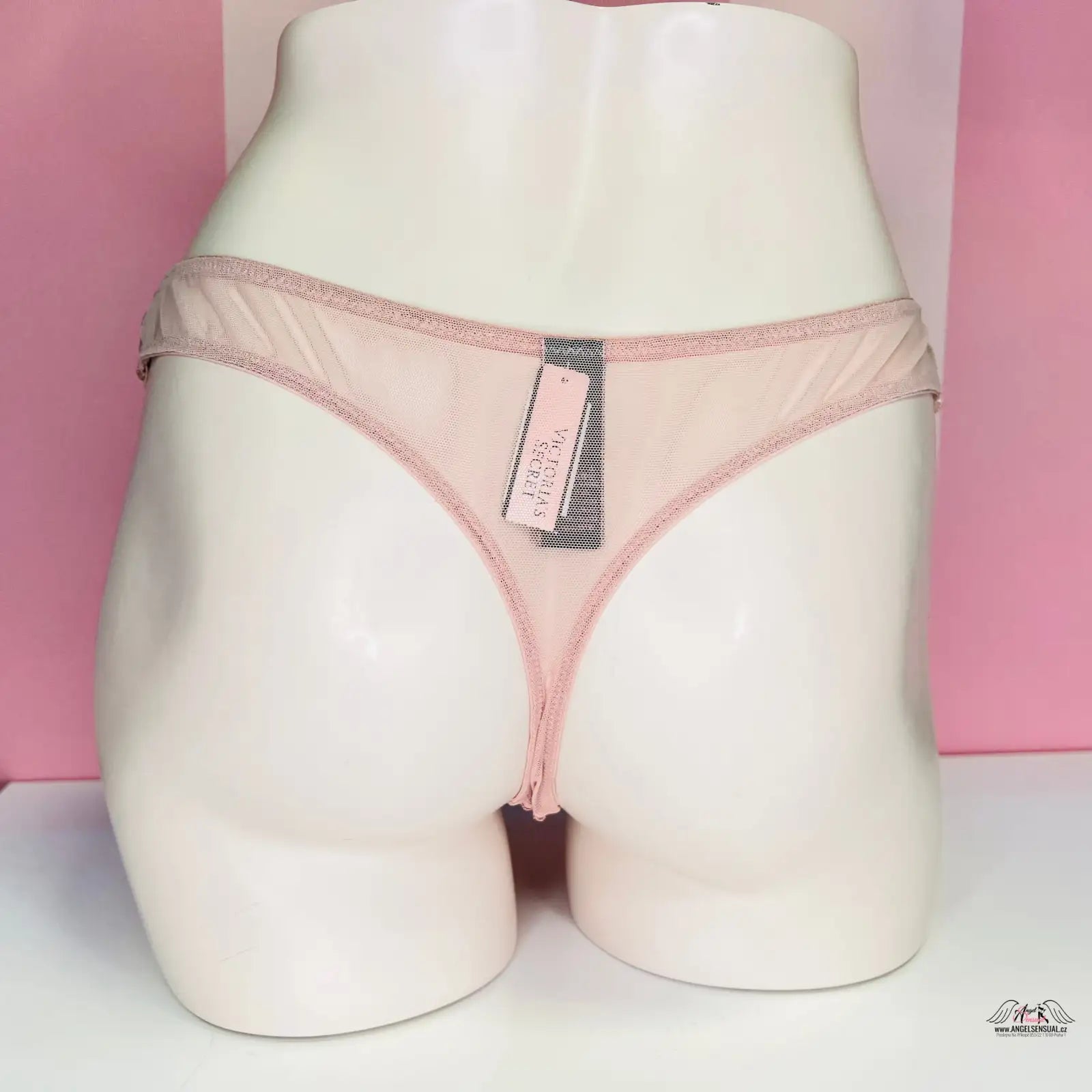 Světle růžové thong kalhotky na bílém modelu s názvem Luxusní Síťované Kalhotky
