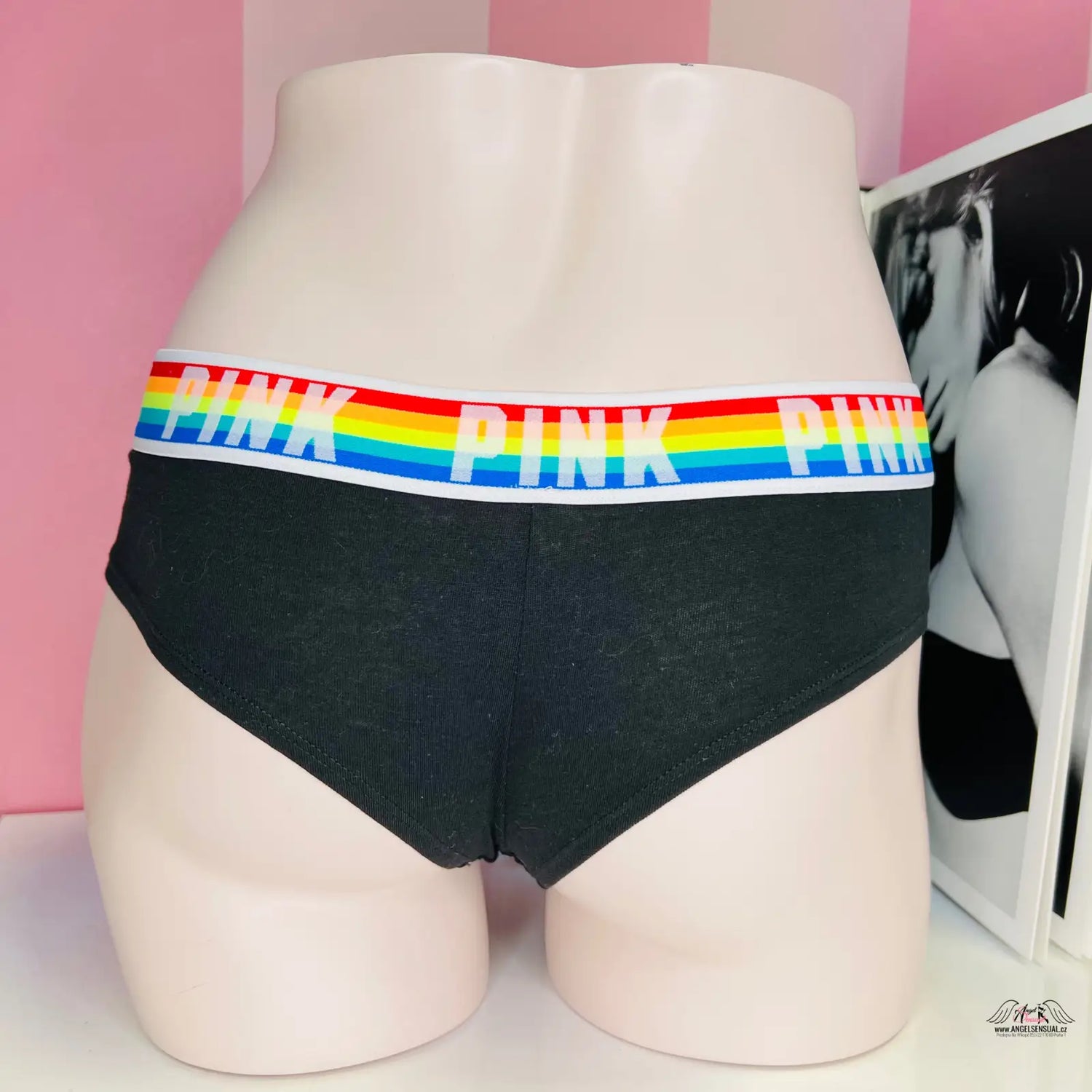 Žena v černých bavlněných tangách Victoria’s Secret s duhovým potiskem