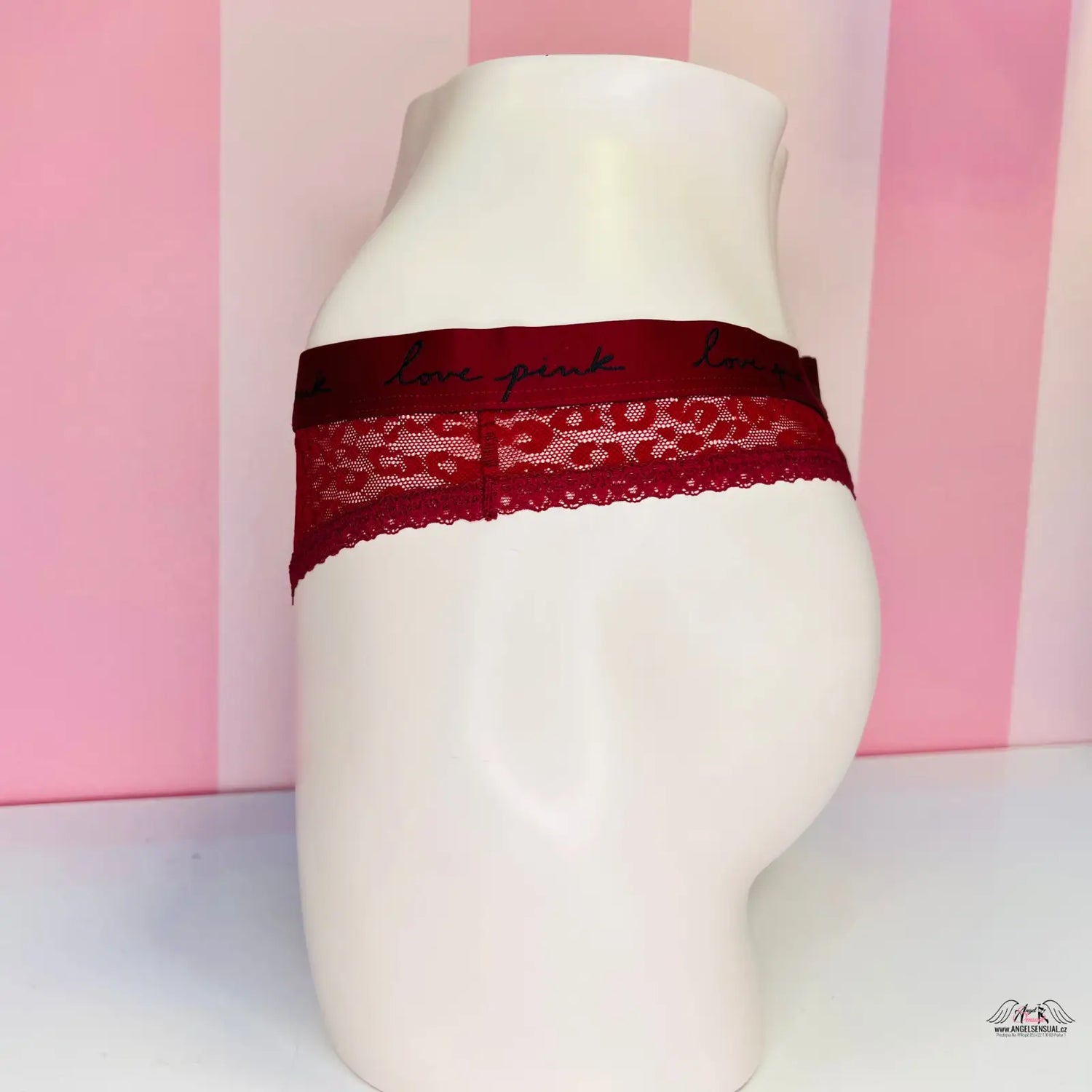 Blízký pohled na modelku s červeným krajkovým páskem u produktu PINK Krajková Tanga, sexy krajkové tanga Agent Provocateur