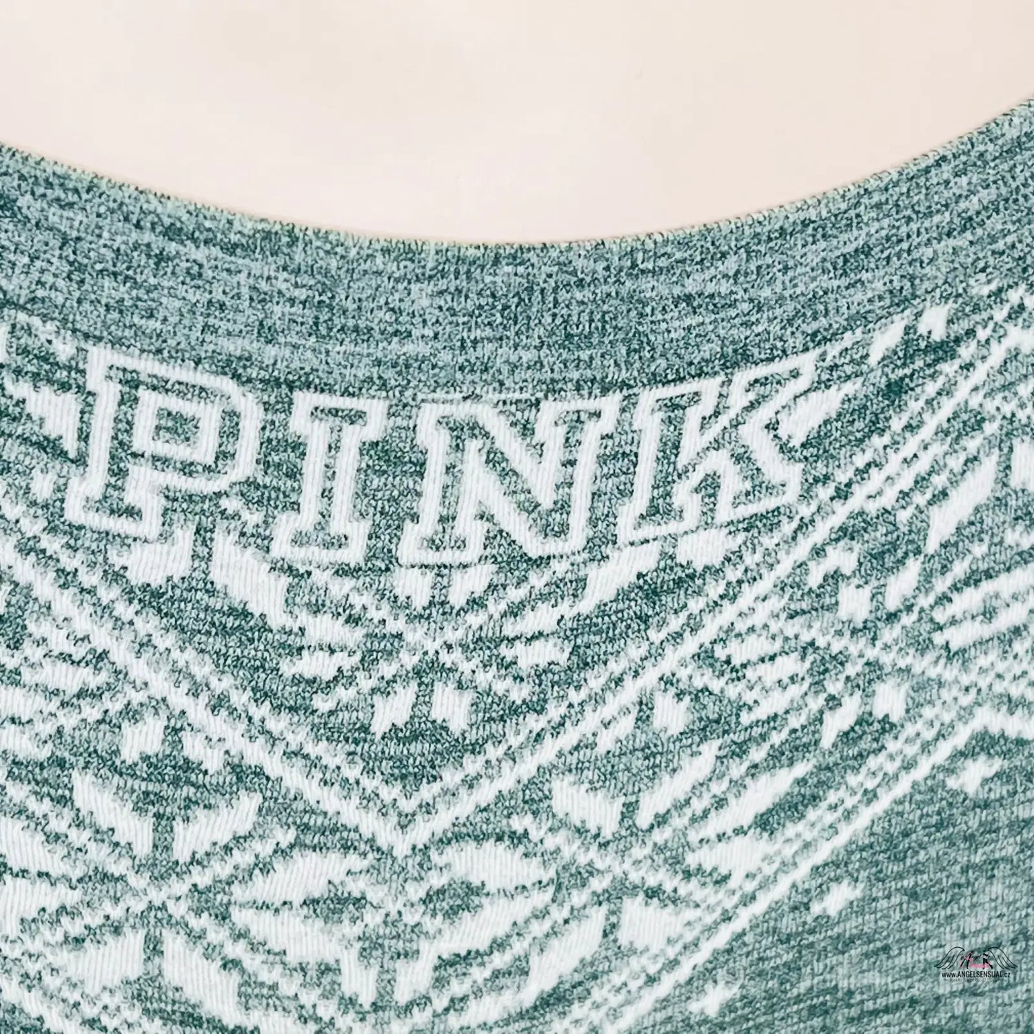 Žena v zeleném svetru s bílým nápisem na PINK Kraťáskové Kalhotky Victoria’s Secret Pink zimním motivem