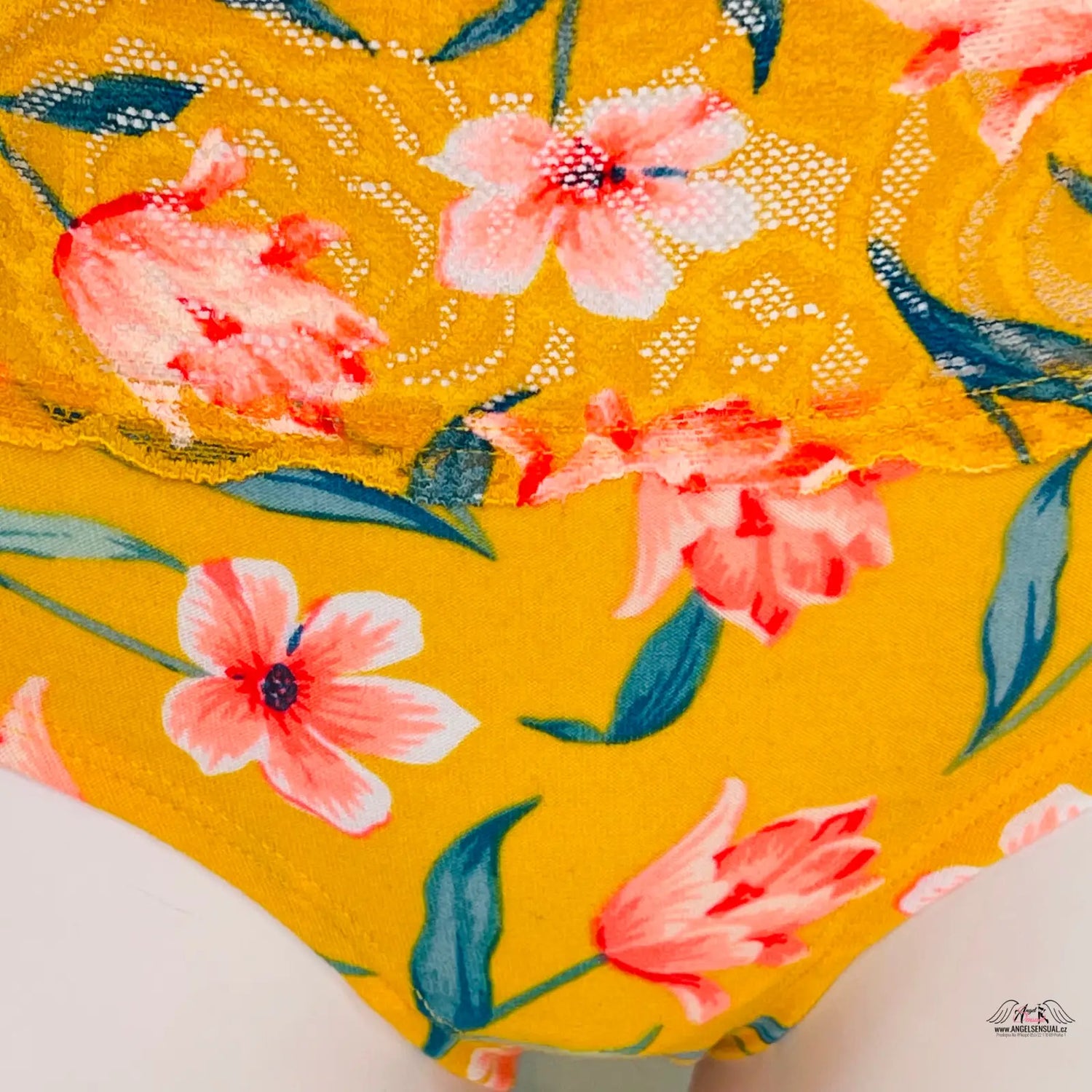 Vibrantní květinový motiv na žlutých květovaných kalhotkách s krajkovým detailem