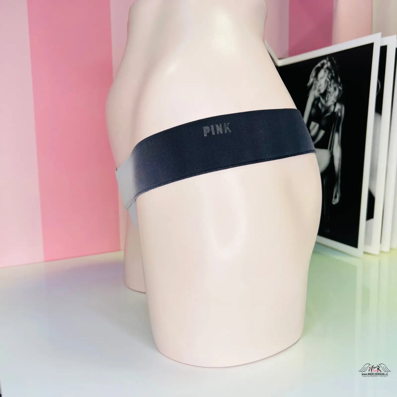 Mannequin v žíhaných šedočerných tangách s nápisem Pink na levé horní straně