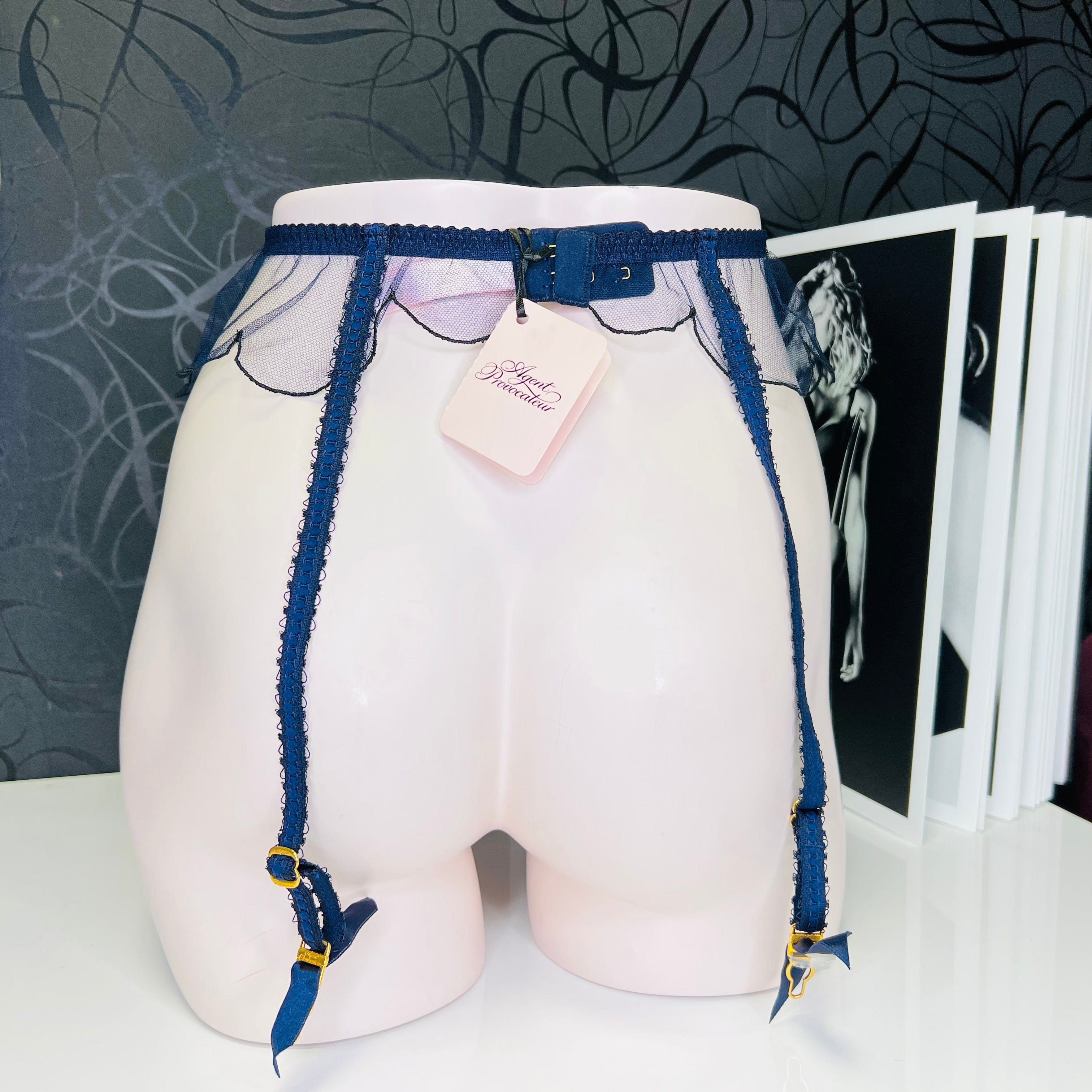 Blue garter belt on mannequin of elegant síťovaný podvazkový pás Lorna with golden details