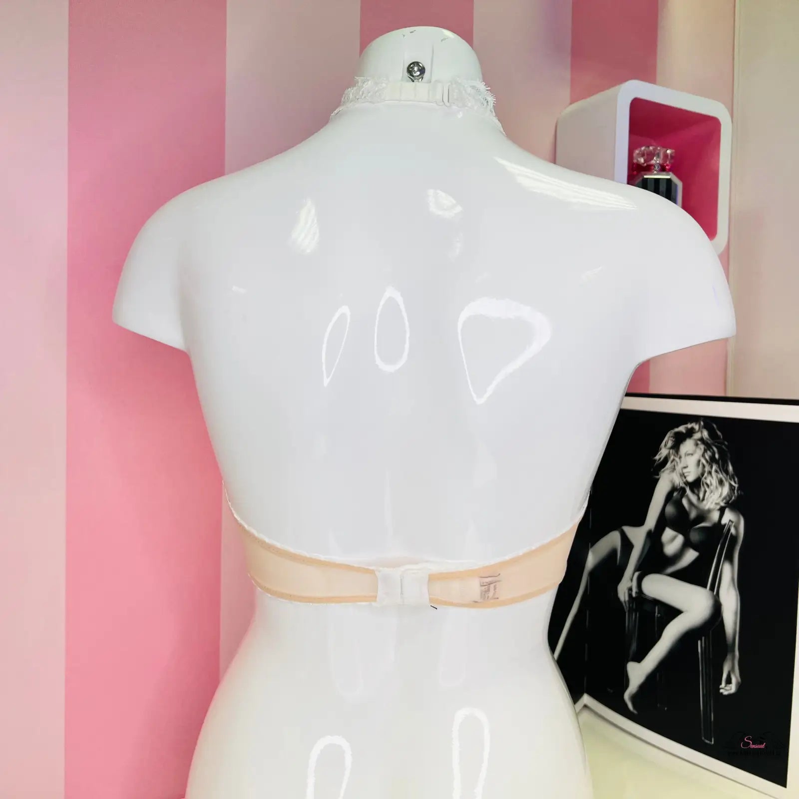 Bílý manekýn s béžovým krejčovským metrem kolem pasu a braletka Victoria’s Secret