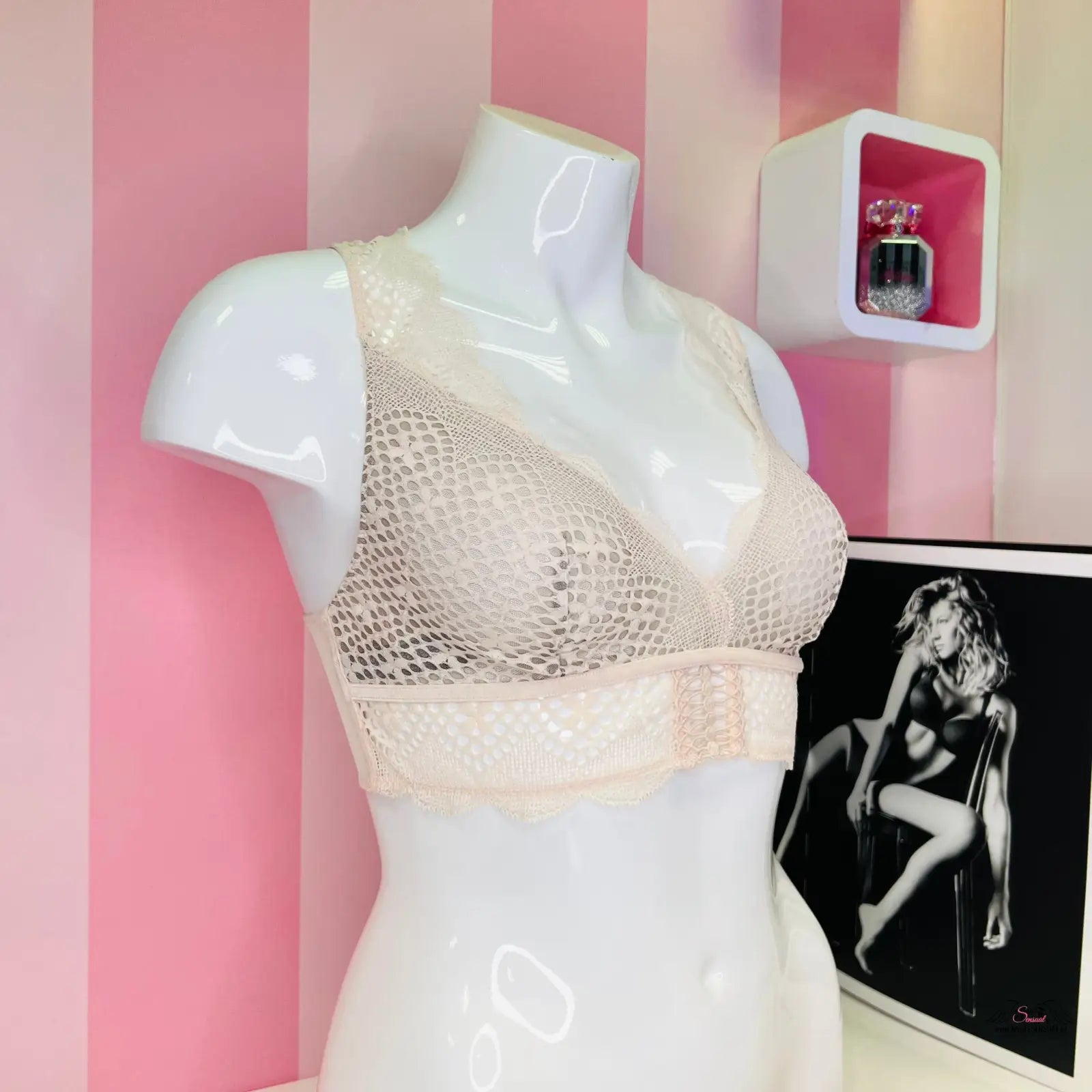 Arachnoidní manekýn s velmi sexy bralette Victoria’s Secret na růžové pruhované zdi