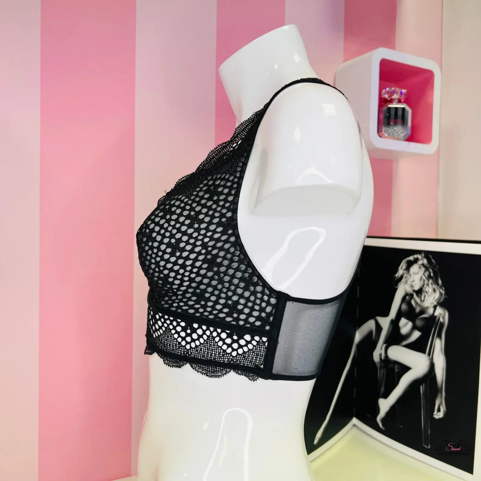 Manekýn s velmi sexy bralette Victoria’s Secret na růžovo-bílé pruhované zdi