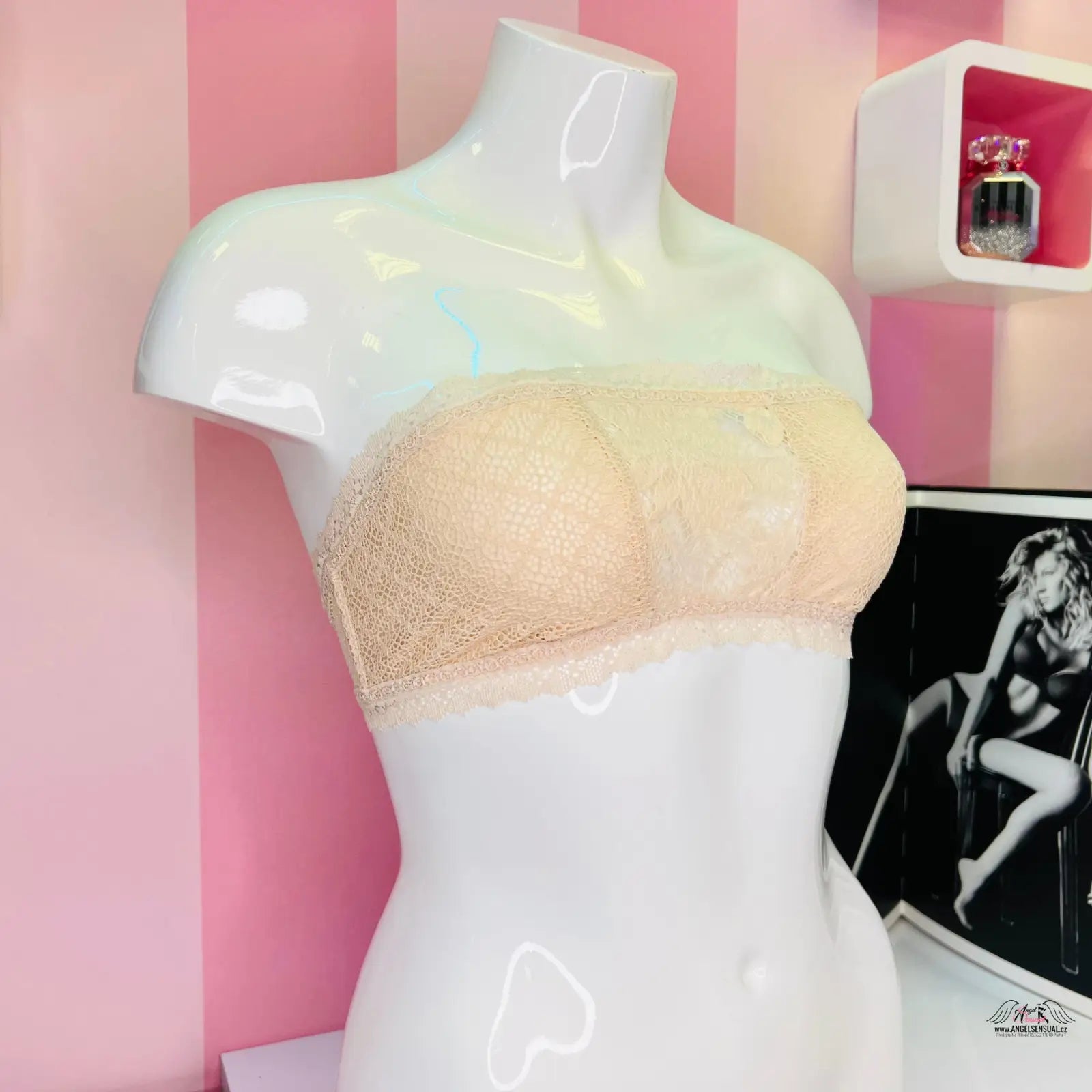 Manekýn v místnosti s růžovou stěnou, krajková braletka v stylu agent provocateur