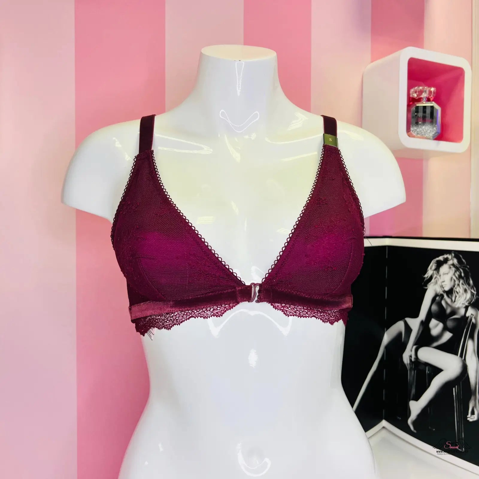 Krajkový červený bralette Victoria’s Secret na figuríně s růžovou pruhovanou zdí