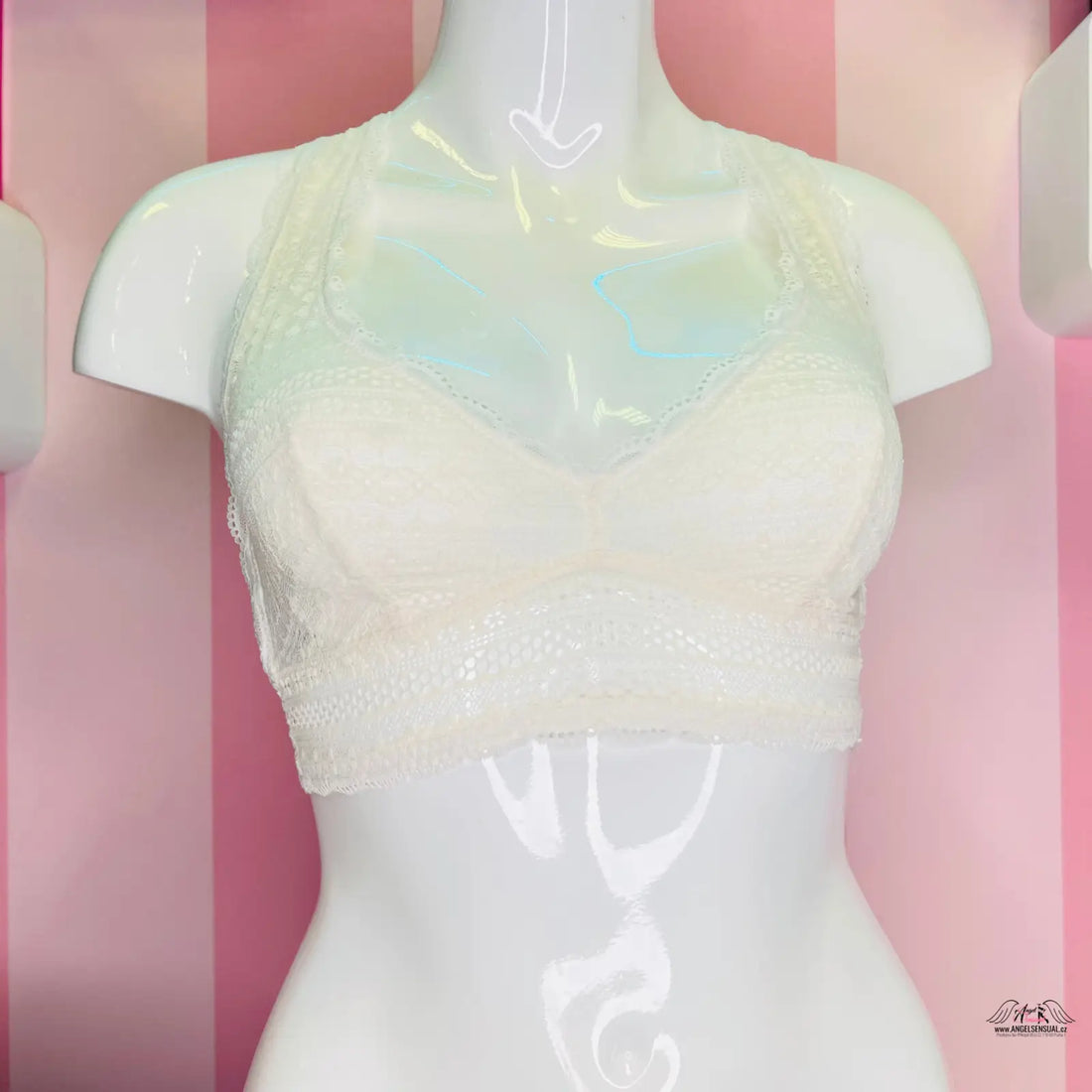 Manekýn s bílou lákavou krajkovou braletkou na růžové pruhované zdi, ideální pro speciální příležitosti