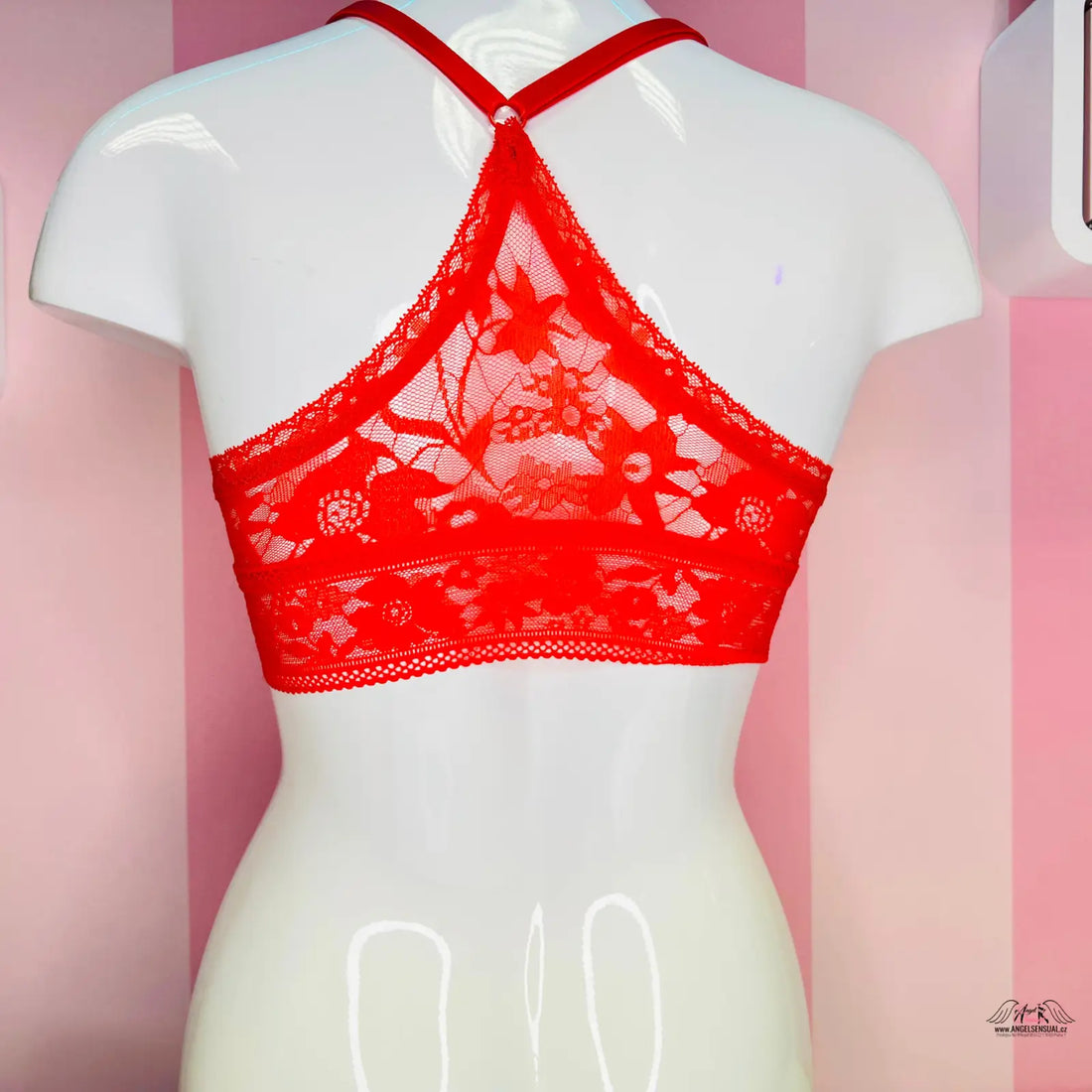 Sexy červená krajková braletka secret lace s kříženými popruhy na bílém modelu