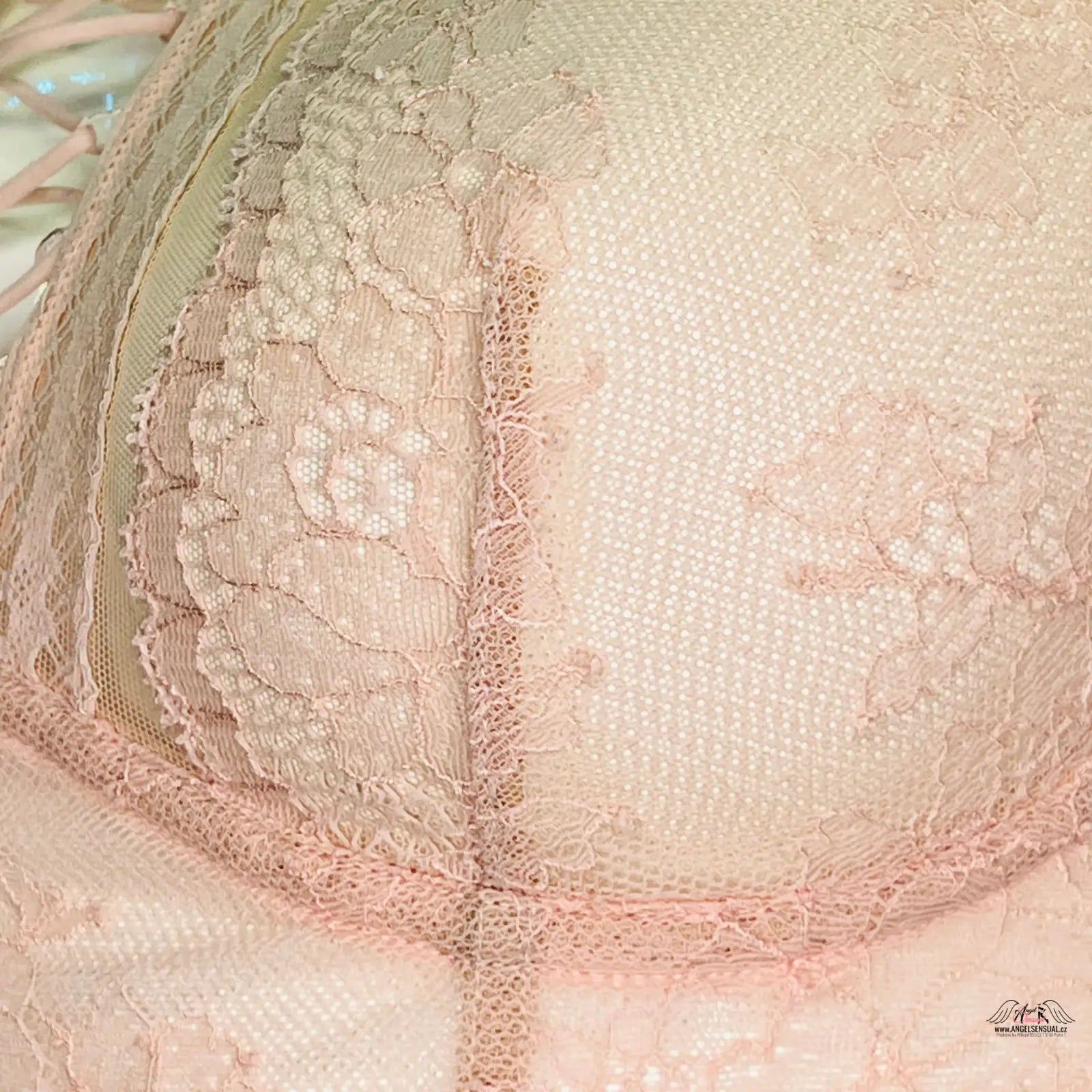 Detailní pohled na růžovou podprsenku Victoria’s Secret s krajkou a překříženými ramínky