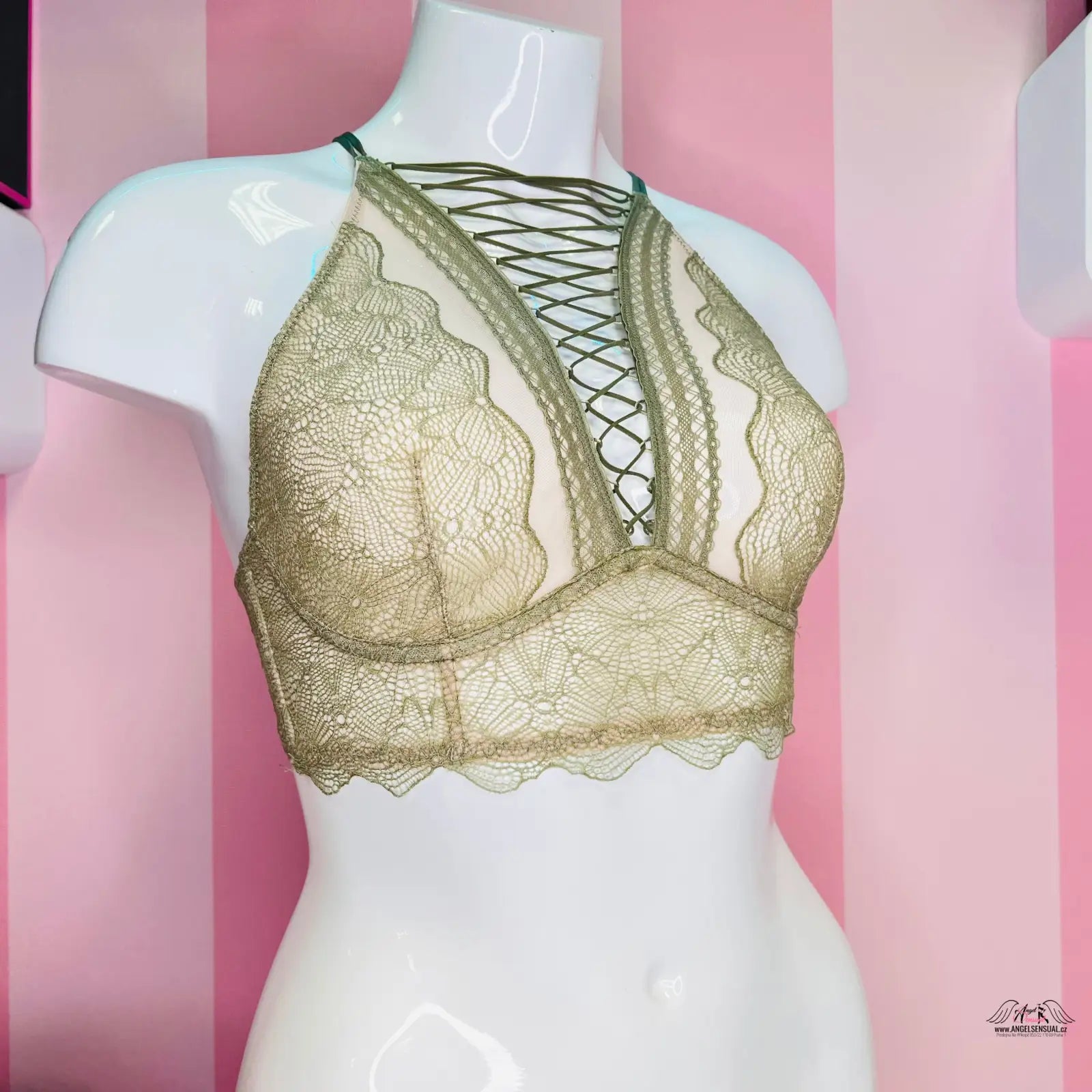 Detailní záběr na manekýna s zlatou braletkou s vyšívanou krajkou od Victoria’s Secret