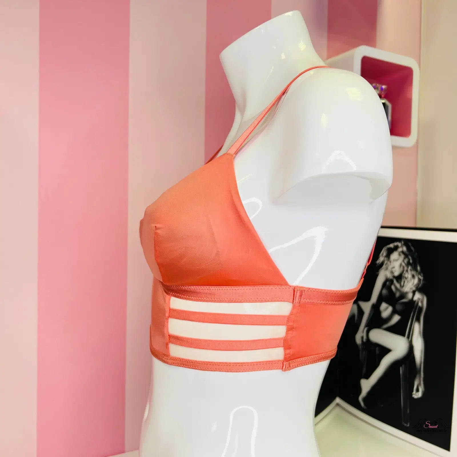 Peach-colored soft stretch bralette with three white stripes on mannequin torso