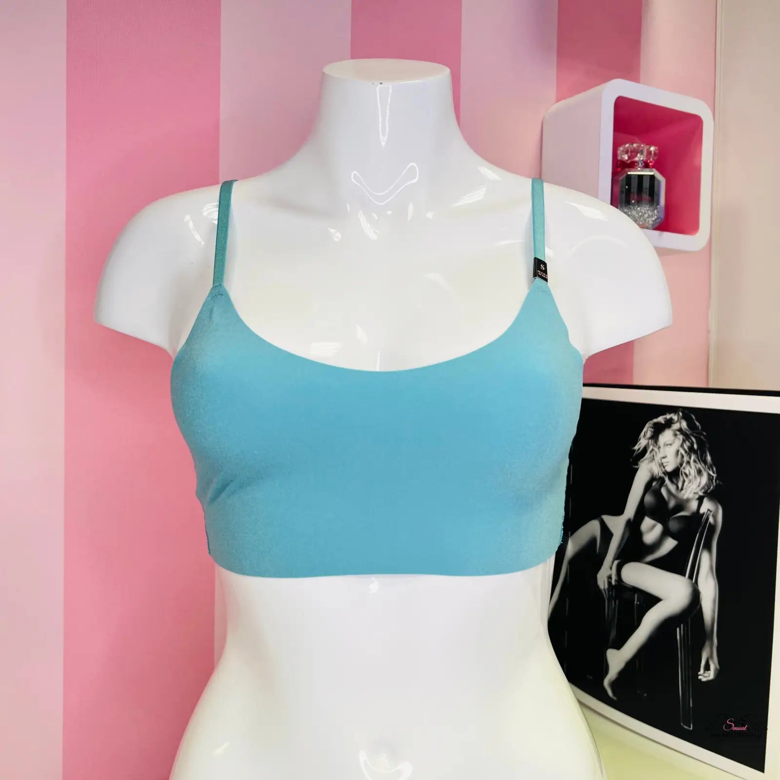 Manekýn s modrou stylovou braletou Victoria’s Secret a růžovo-bílou pruhovanou stěnou