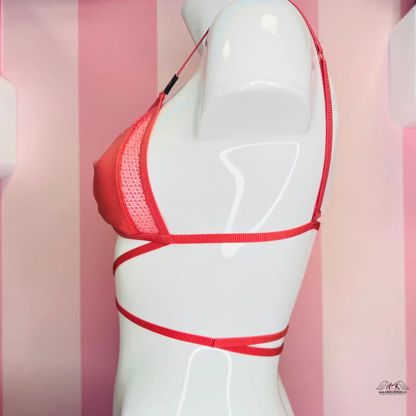 Manekýn s červenou podprsenkou na růžově pruhované stěně Victoria’s Secret