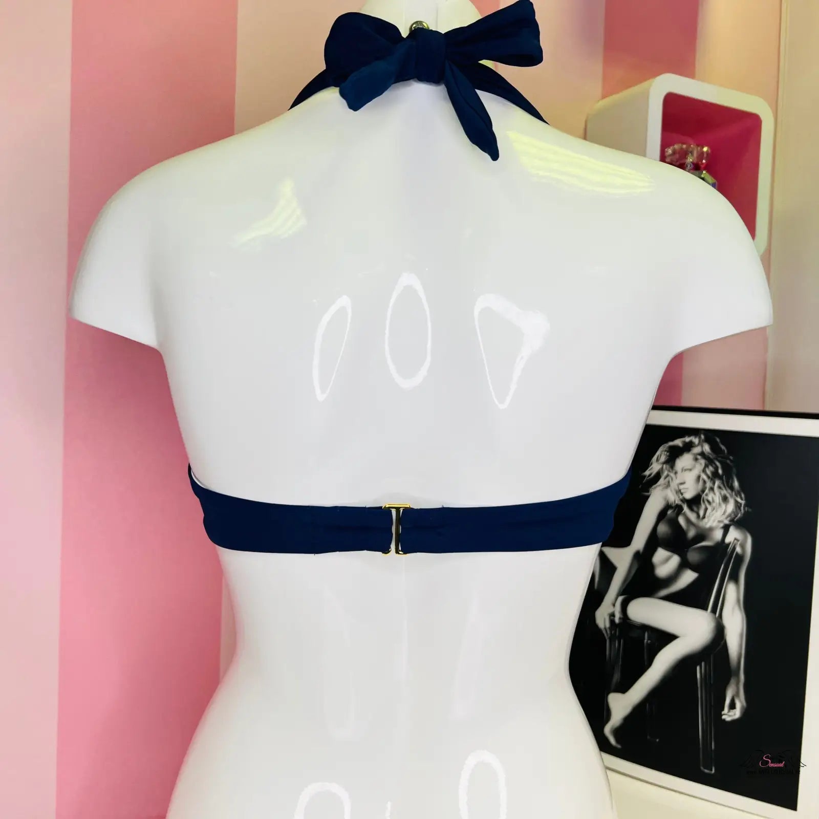 Bílý manekýn s černou mašlí na krku a modrým páskem, horní díl plavek Victoria’s Secret
