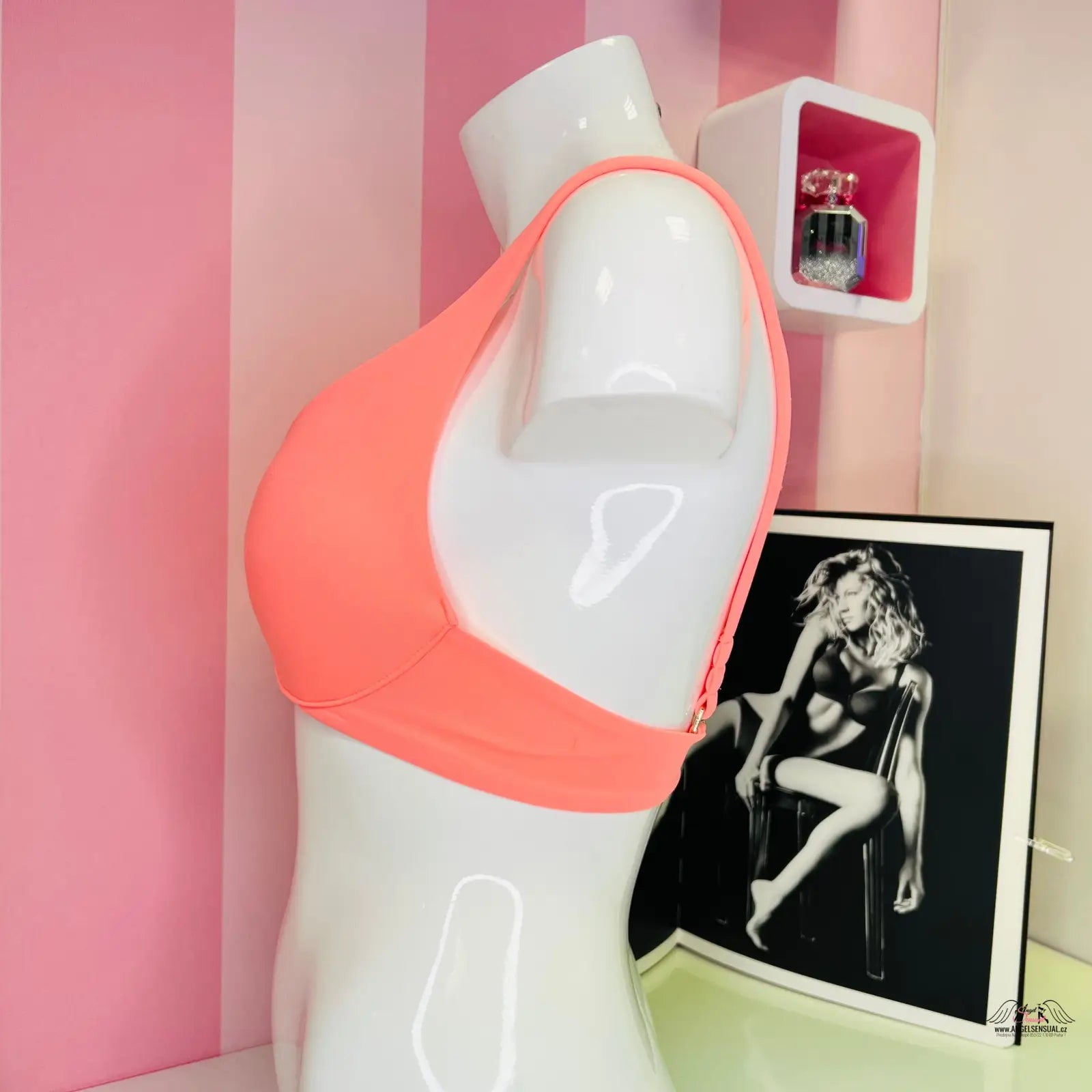 White mannequin torso wearing coral-colored sports bra from Victoria’s Secret Horní Díl Plavek Lososové se Zlatým Akcentem, elegantní horní díl plavek s jemnou zlatou ozdobou