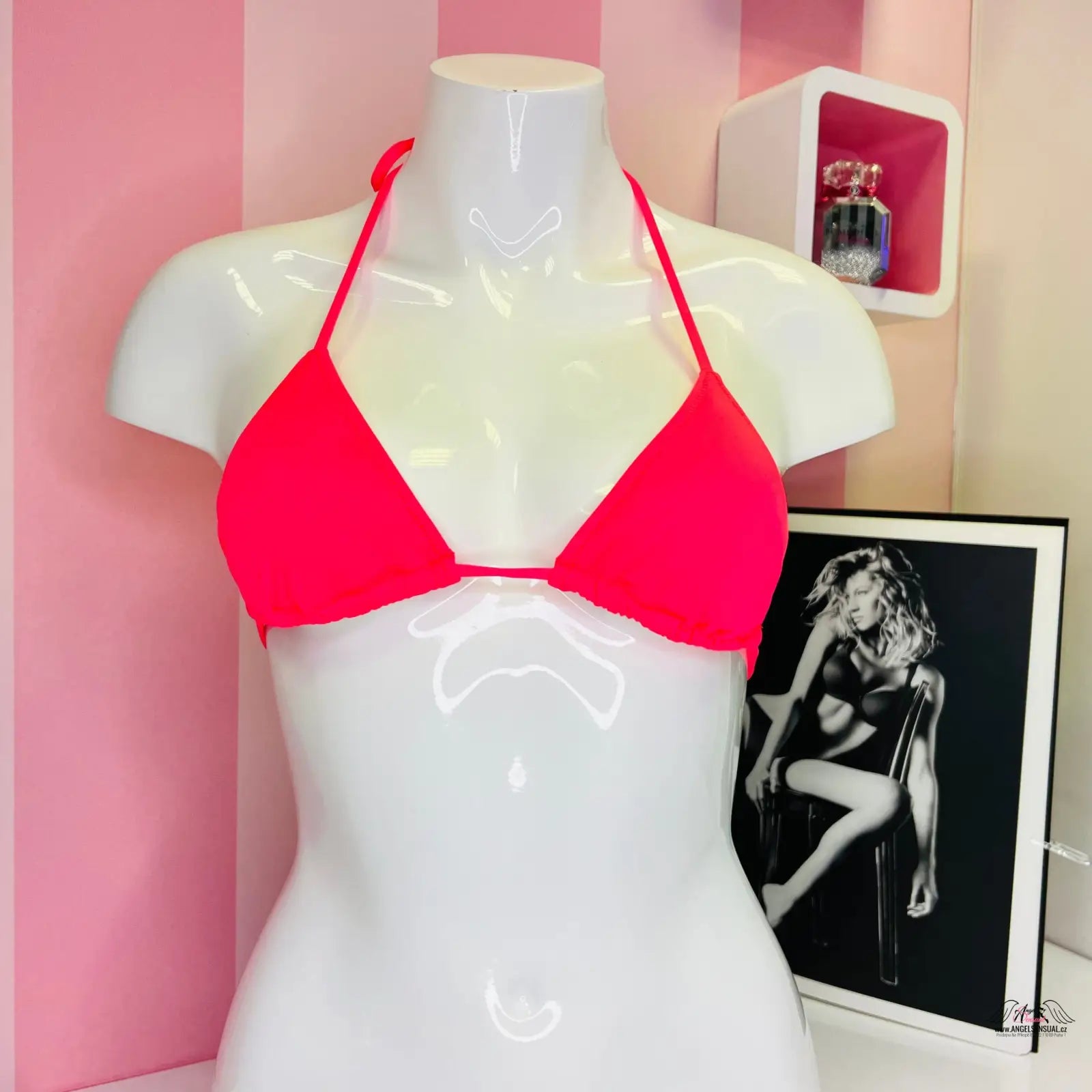 Manek s červeným trojúhelníkovým bikiny topem a černobílou fotografií, stylový plážový vzhled