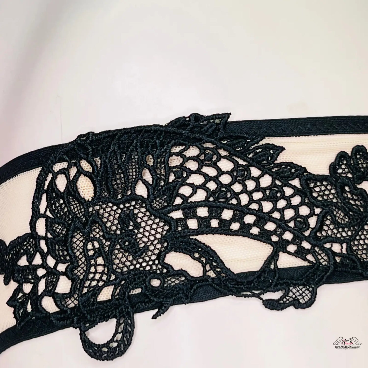 Černá krajková garterka Victoria’s Secret s jemnou krajkou na bílém pozadí
