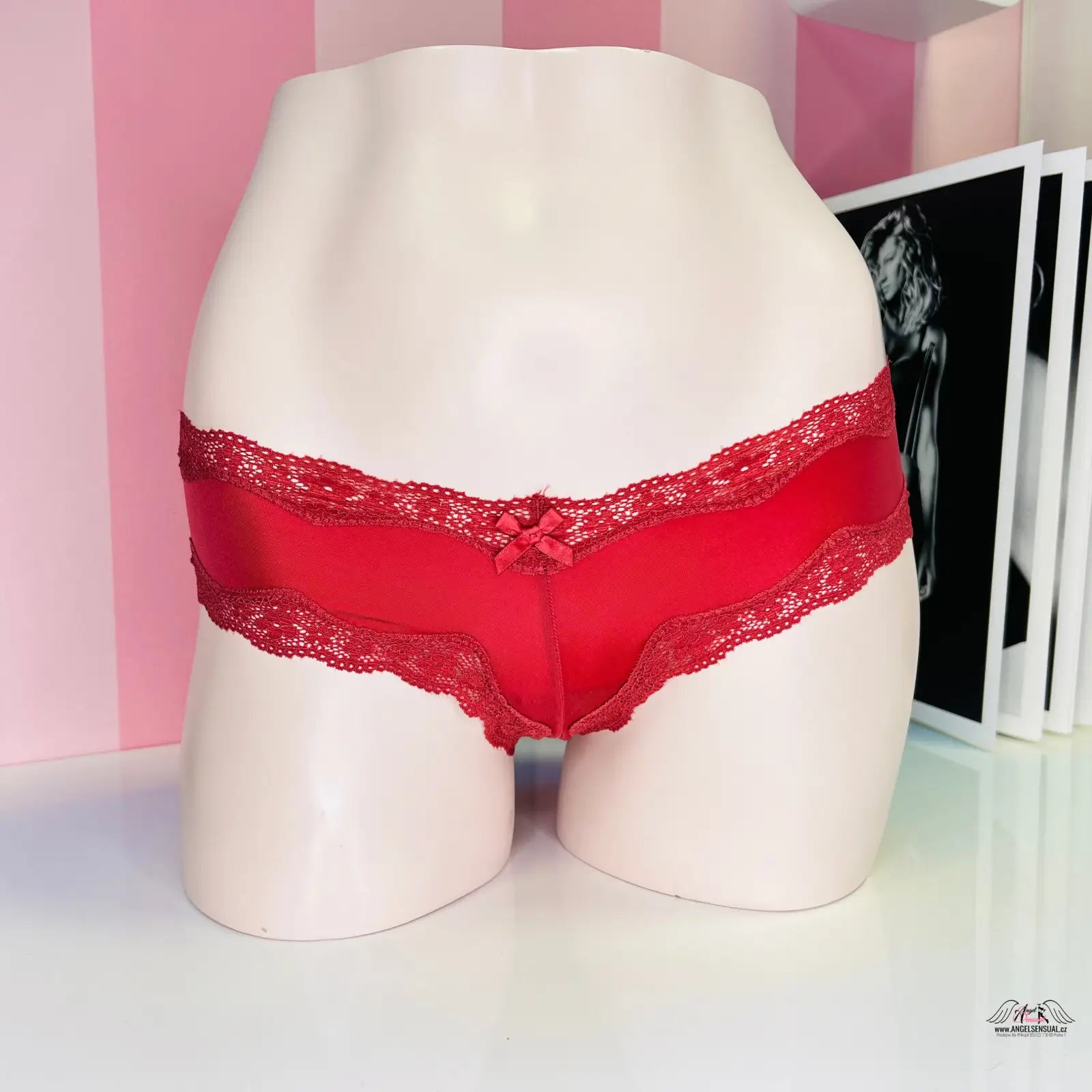 Red lace-trimmed lesklé kalhotky na figuríně, ideální pro speciální příležitosti