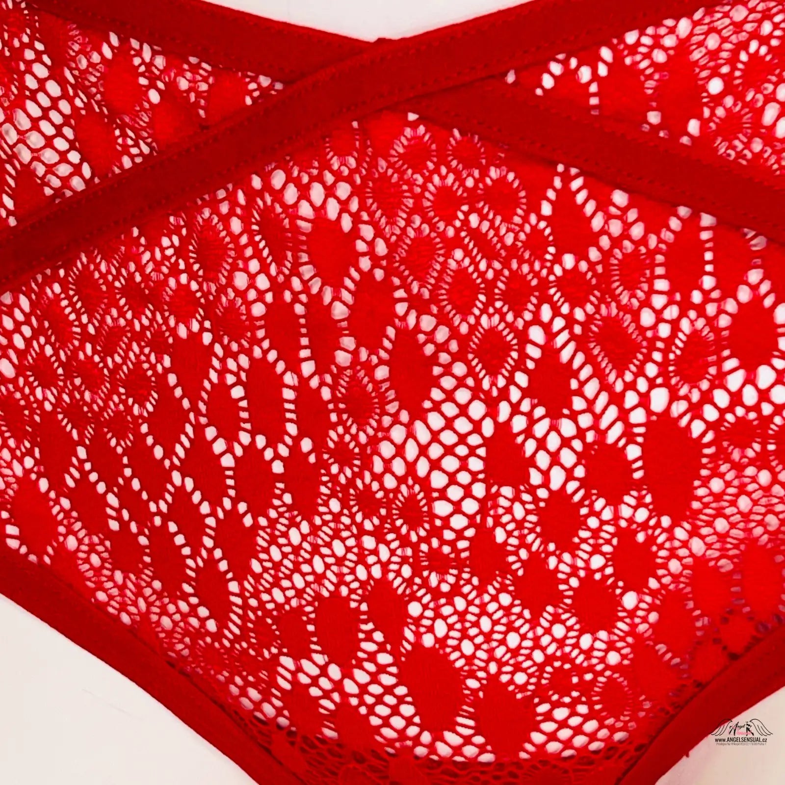 Red lace lingerie s ozdobnými pásky a zlatou ozdobou s zlatým kroužkem