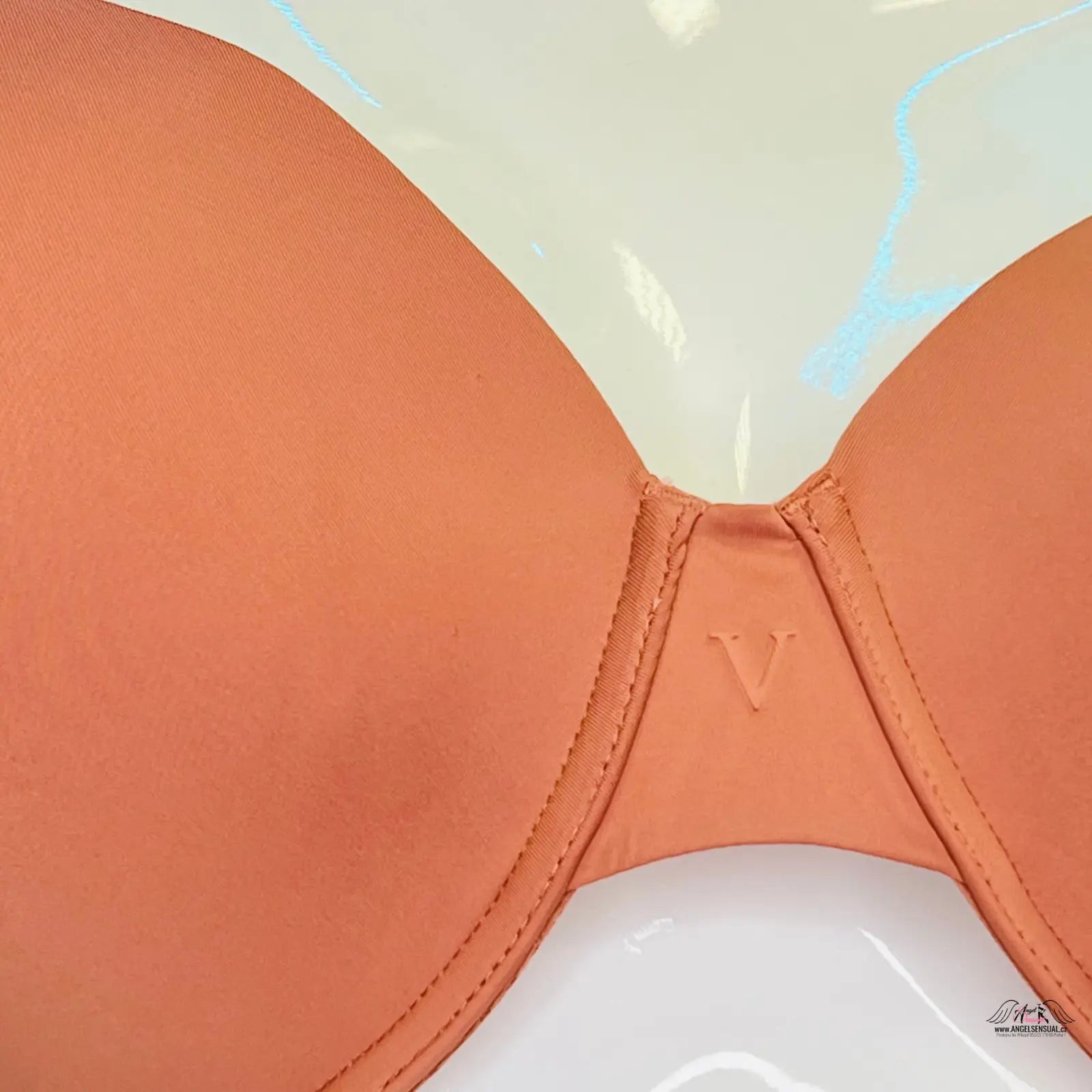 Peach-colored hladká podprsenka s jemnou krajkou a viditelným švem na zádech