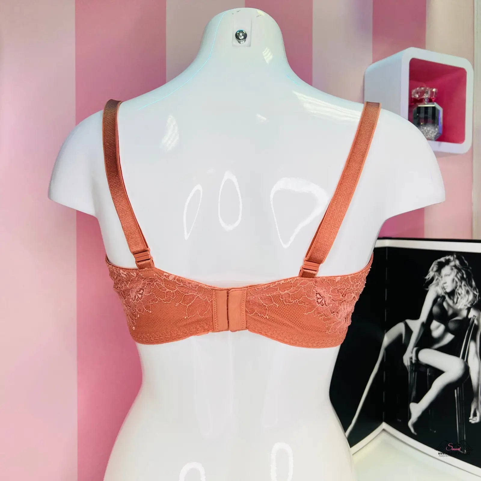 Peach-colored lace bra with jemnou krajkou and hladkými košíčky on a white mannequin