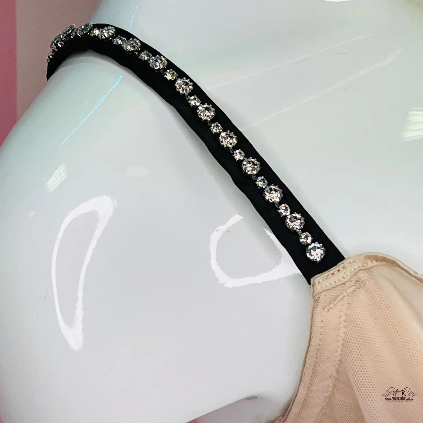 Krásná krémová podprsenka s výraznou mašlí uprostřed a rhinestone-studded strap