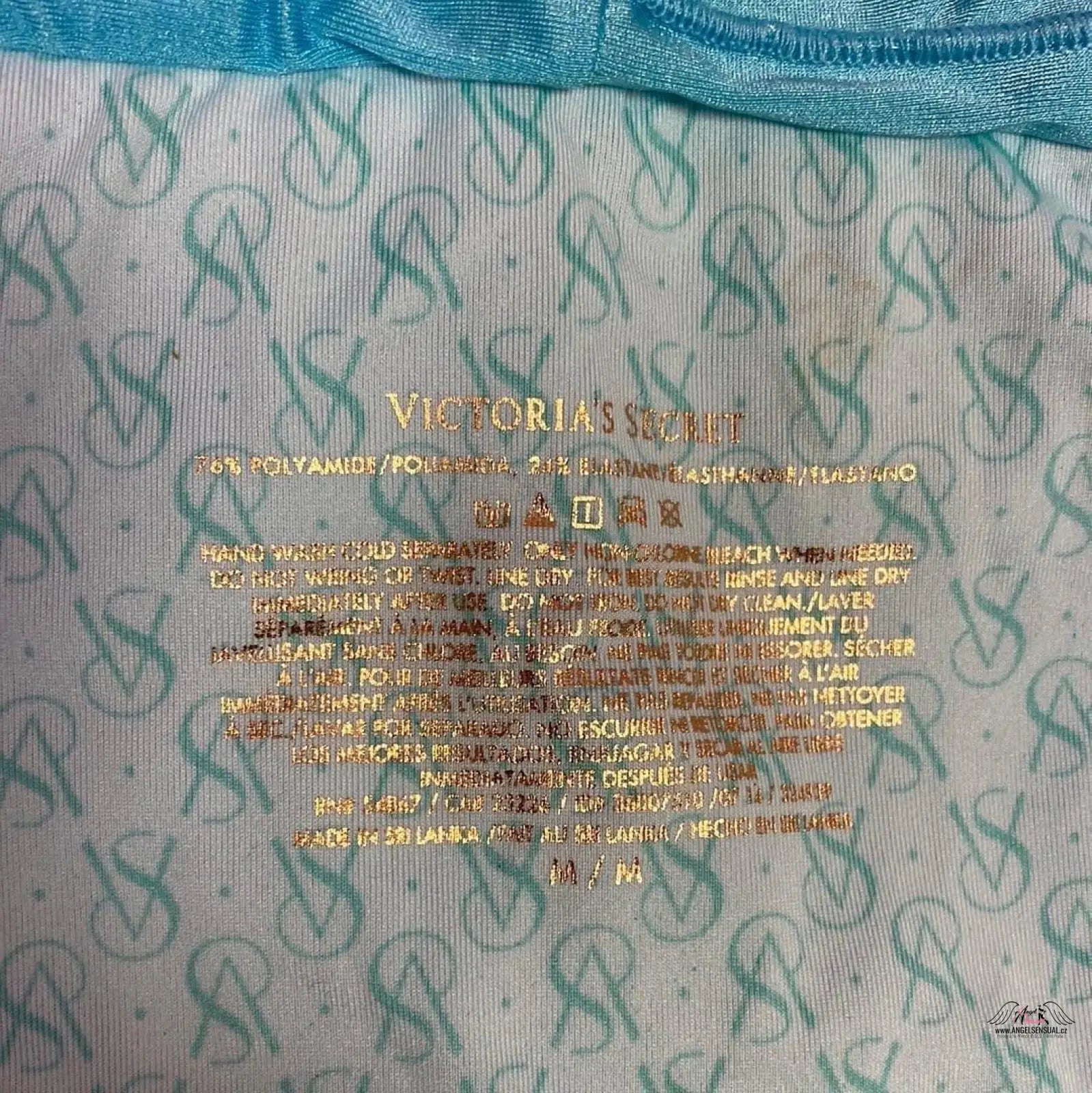 Victoria’s Secret garment care label na spodním dílu plavek se zlatou aplikací a lesklými odlesky