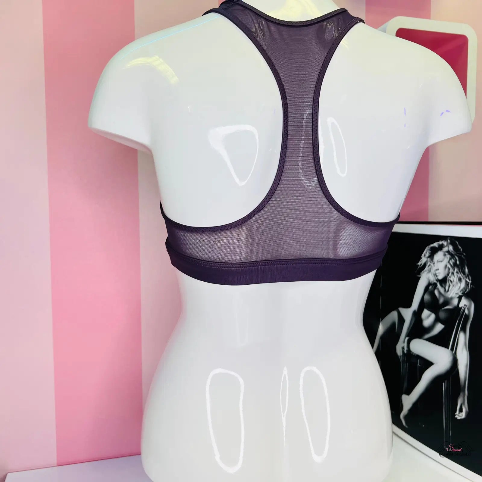 Arafed mannequin s černou sportovní podprsenkou Victoria’s Secret na růžové stěně