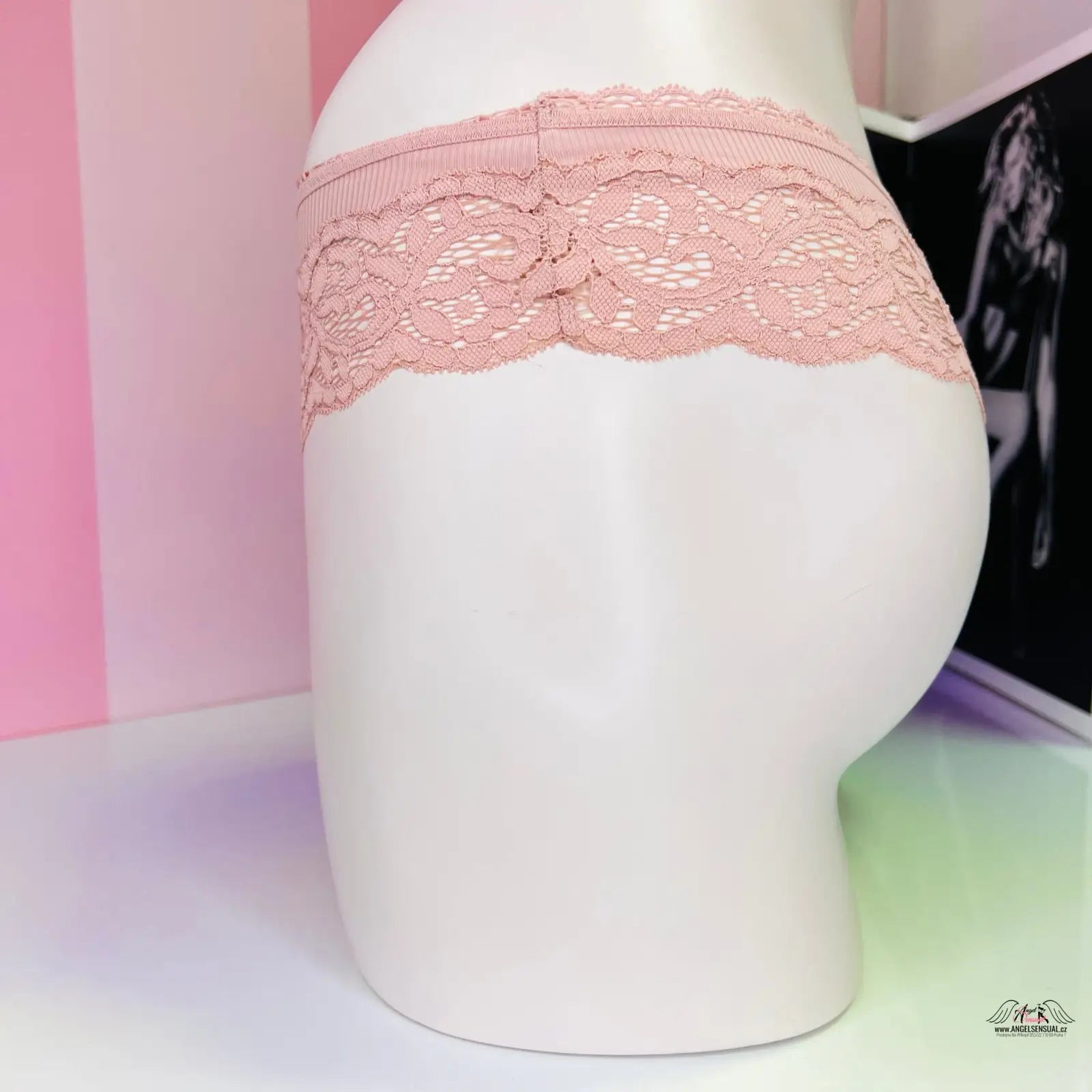 Bílá manekýnka s růžovým krajkovým páskem na tělová krajková tanga Victoria’s Secret