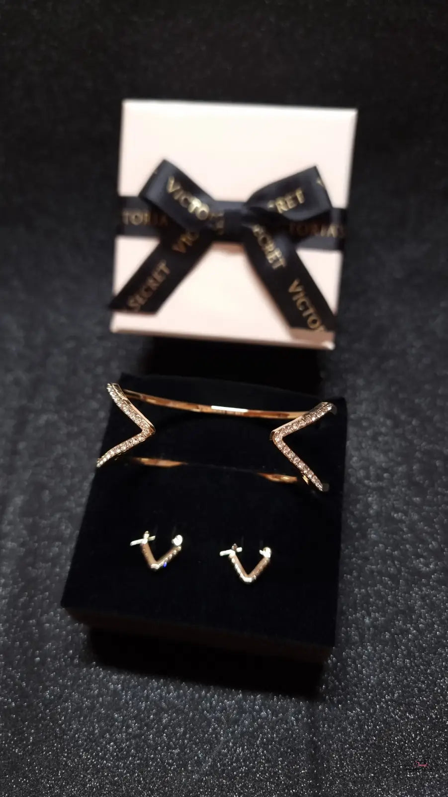 Obrázek zlatého setu náušnic a náramku Victoria’s Secret s krabičkou