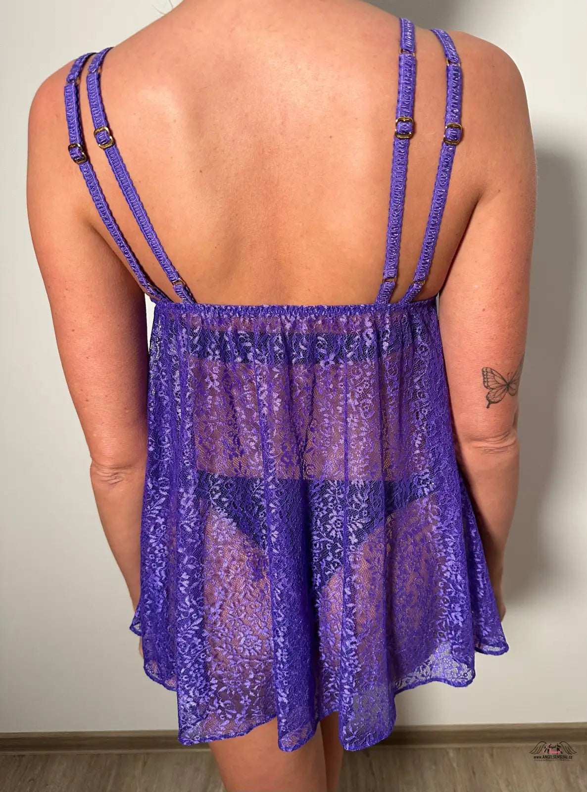 Žena v purpurovém topu s květinovým vzorem nosí Zářivé Rei Babydoll od Agent Provocateur