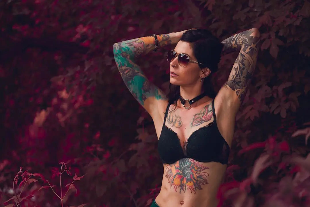 Žena s tetováním v černém bikinách a slunečních brýlích, vývoj spodního prádla.