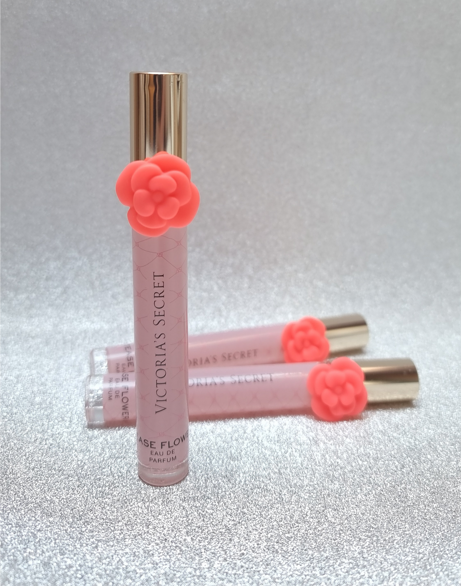 Victoria’s Secret Tease Flower perfume rollerballs with coral flower accents