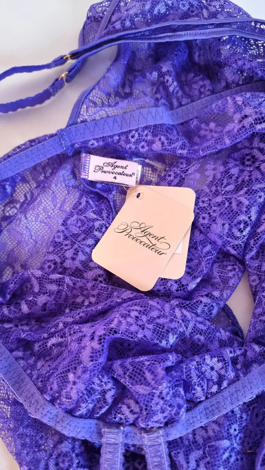 Zářivá Rei Babydoll od Agent Provocateur s krajkovým fialovým designem a štítky