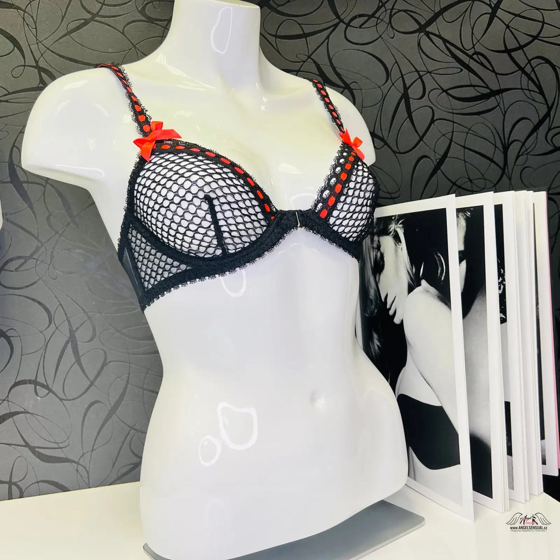 Agent Provocateur Jaccinta podprsenka černá červená na mannequin s časopisem na stole