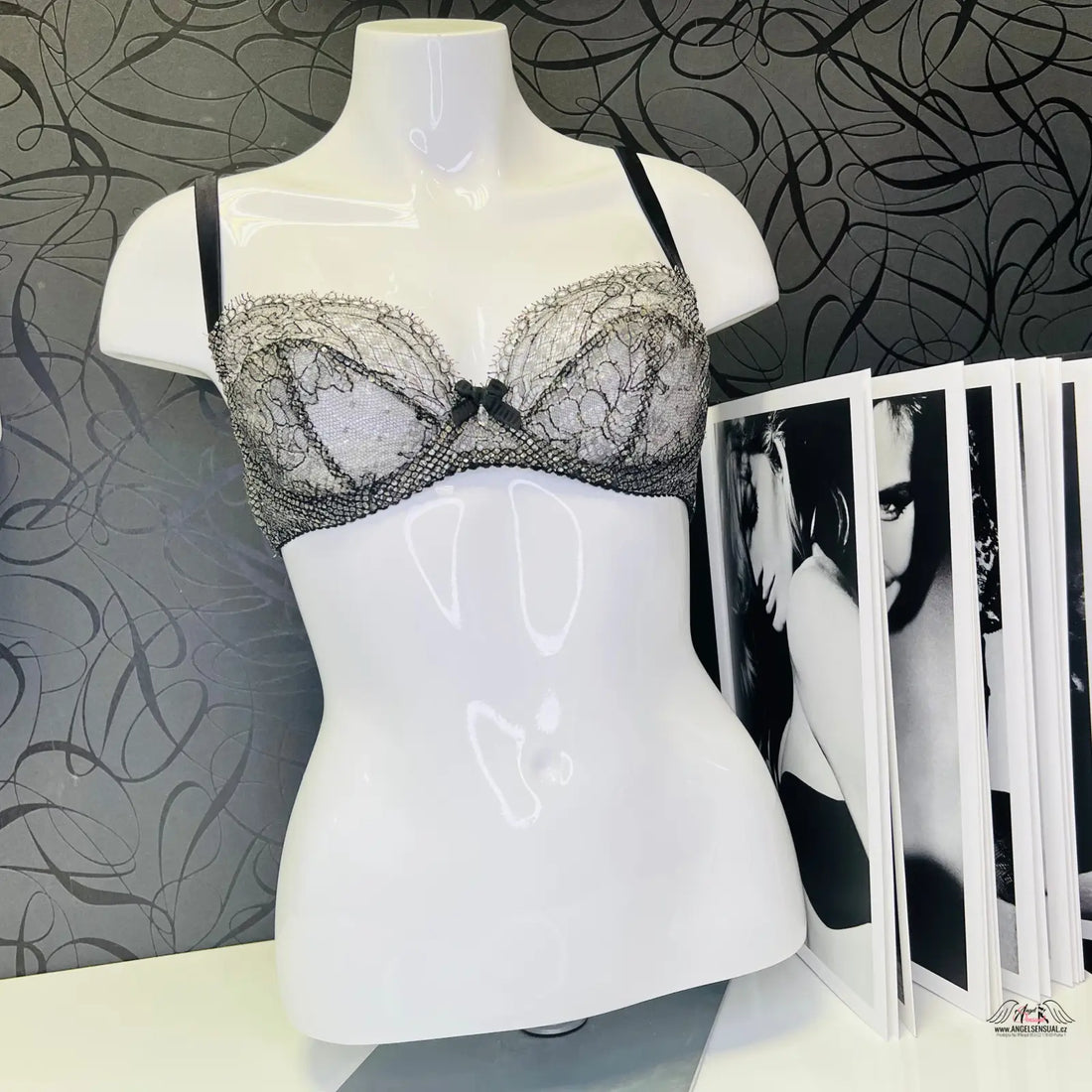 Manekýn s černou stahovací podprsenkou Sianna Black Silver a časopisem na stole