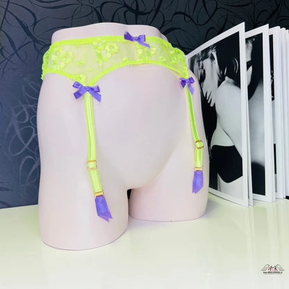 Žena v neonově žlutém tylu s květinovou výšivkou na produktu Agent Provocateur Podvazkový pás Brittnie