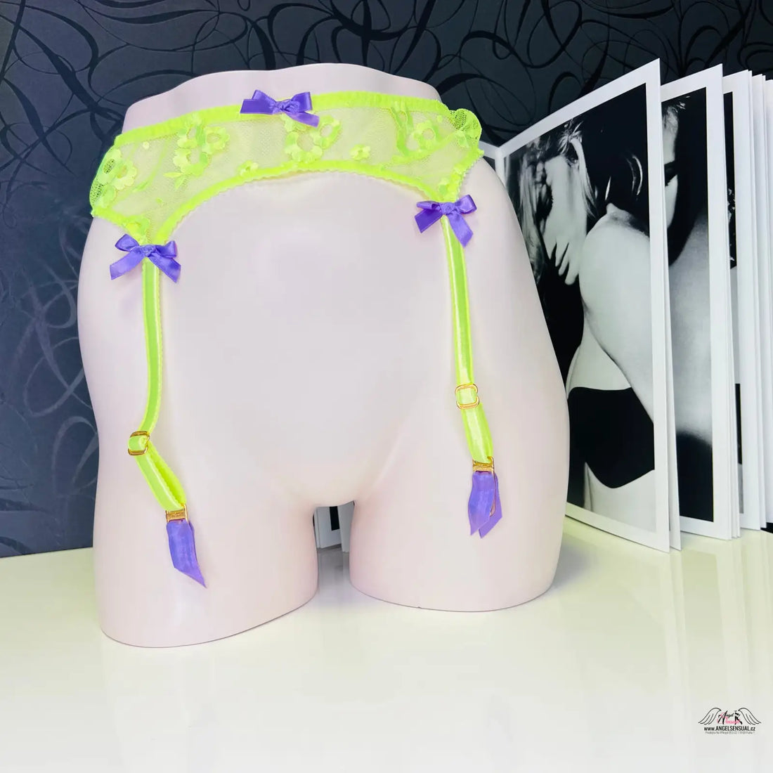 Obrázek bílého muže s zeleným postrojem a fialovými popruhy na Agent Provocateur Podvazkový pás Brittnie s neonově žlutým tyl s květinovou