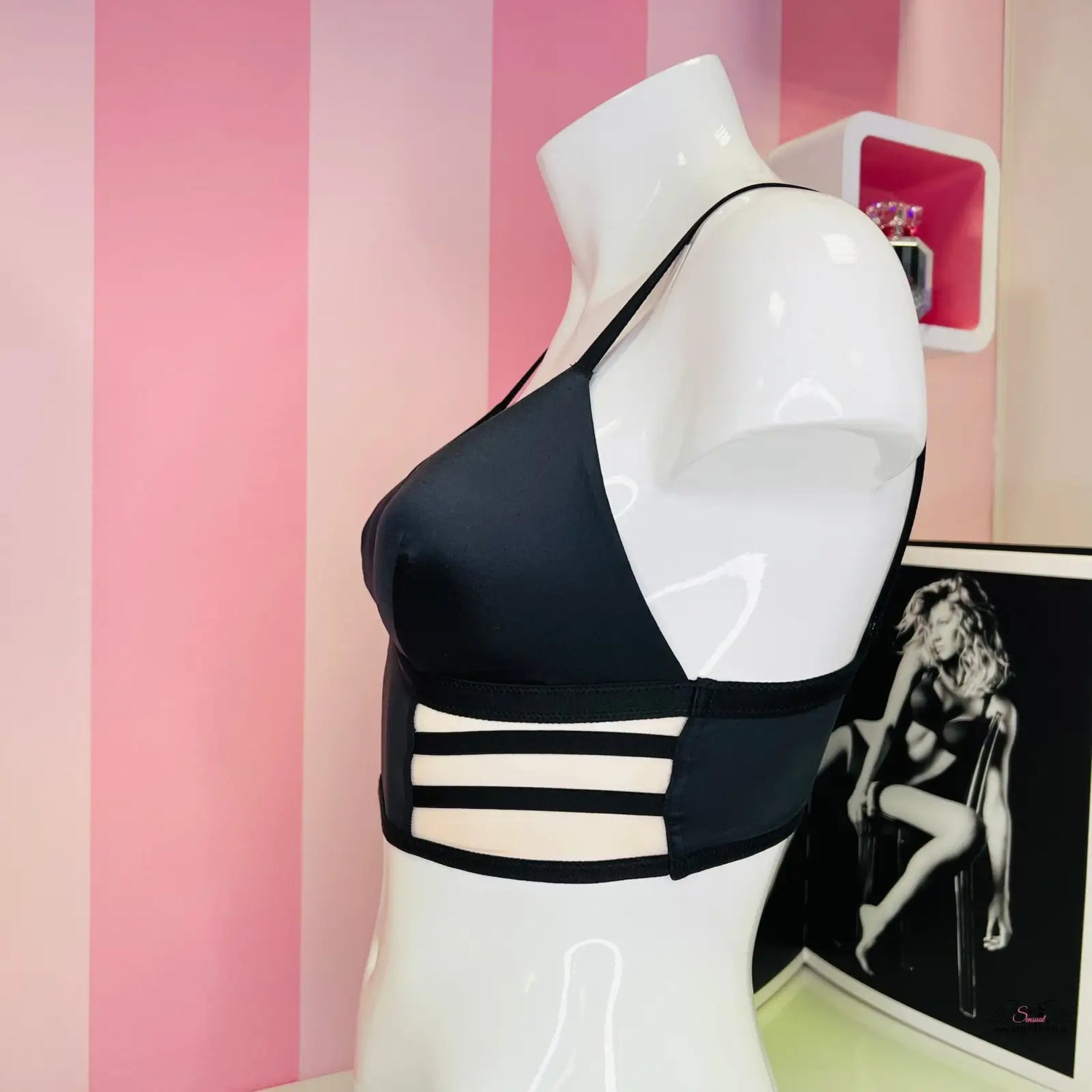 Černá sportovní podprsenka se strappy designem na bílém mannequinu