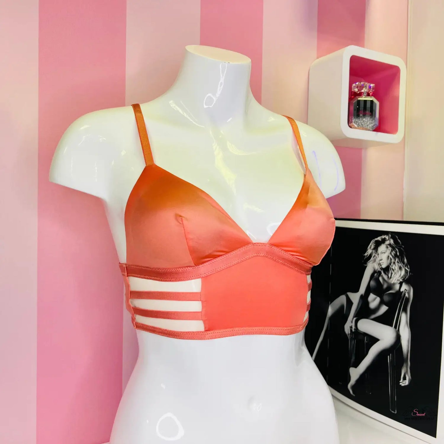 Oranžová braletka se strappy detaily na bílém manekýnu
