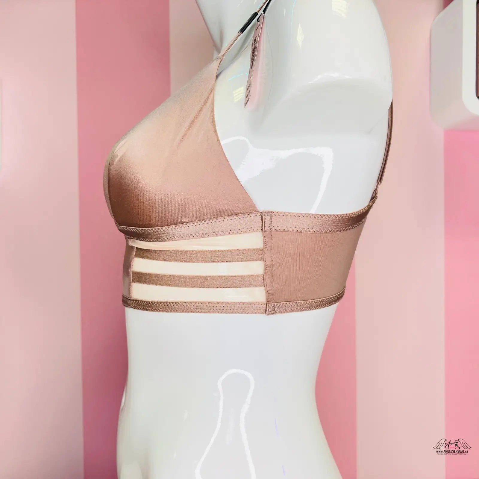 Nude podprsenka s řemínkovými detaily na pozadí růžové barvy