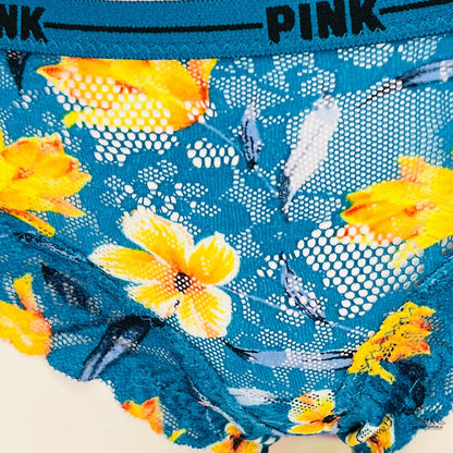 Jasně žlutý květinový vzor na modré krajkové látce s viditelným textem PINK