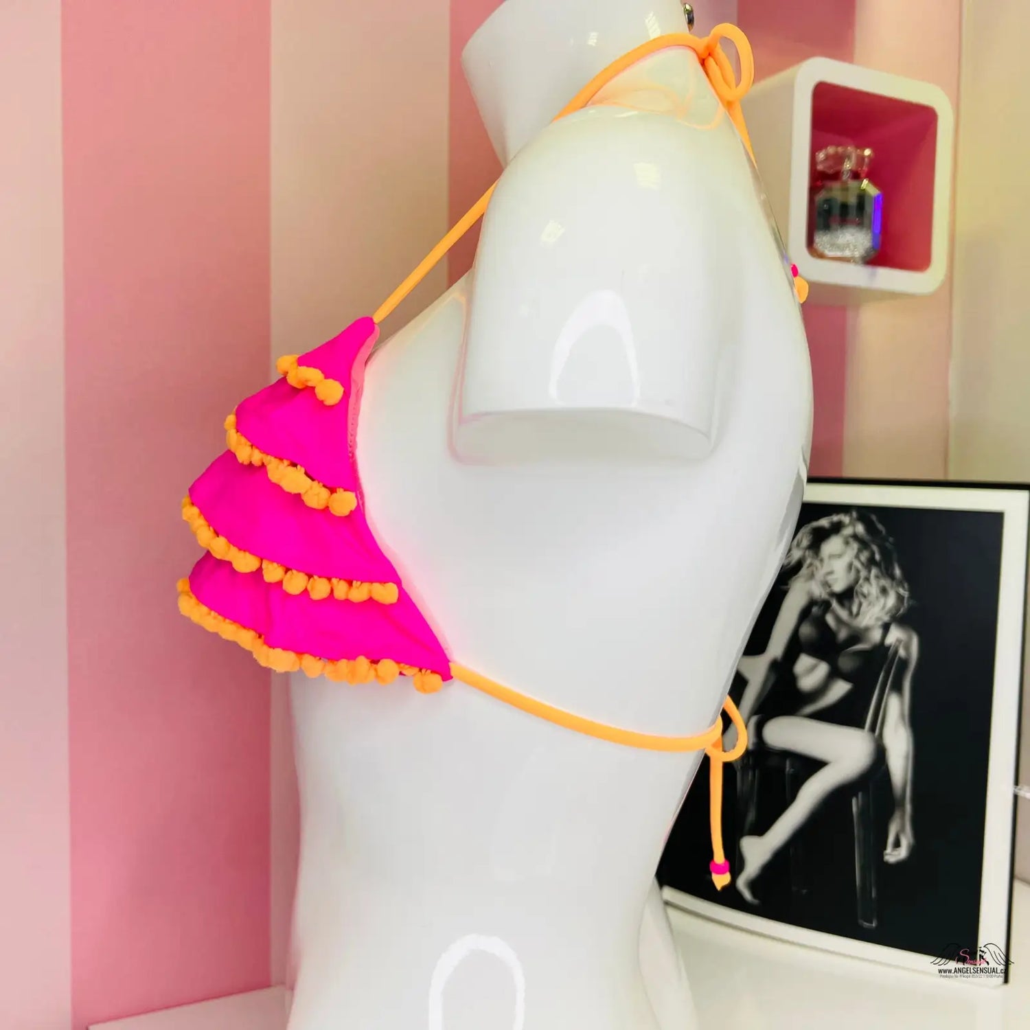 Horká růžová a oranžová volánková bikinová podprsenka na bílém manekýnu